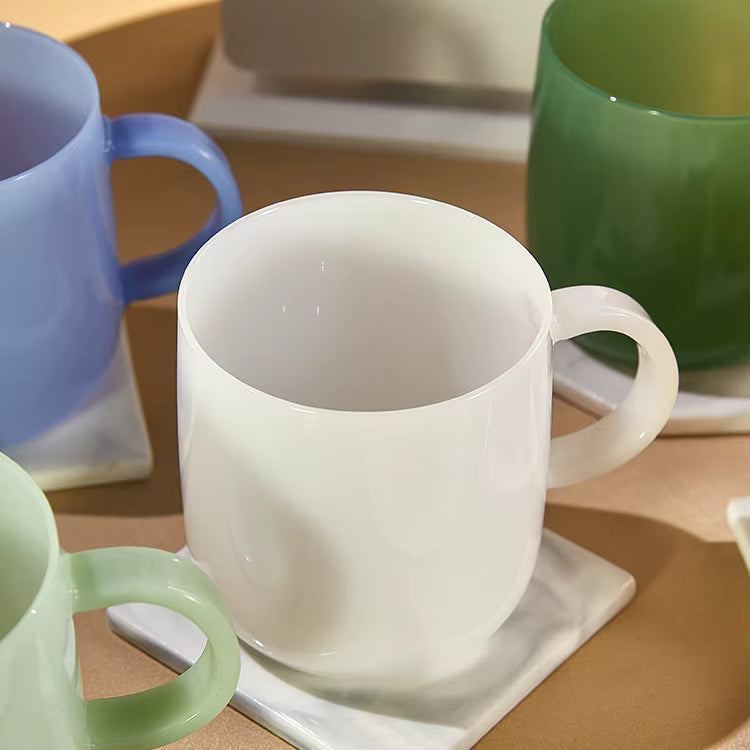 white glass mug lifestyle image on table, custom logo print option for branded merchandise