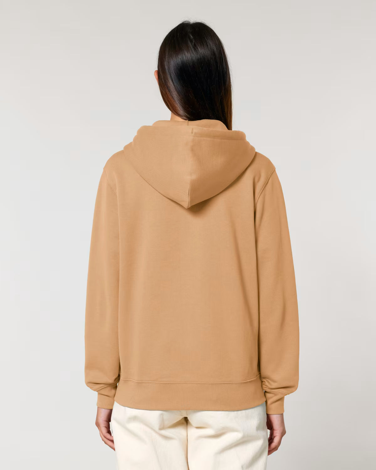 Back view of a male model wearing a mustard yellow cotton hoodie in studio