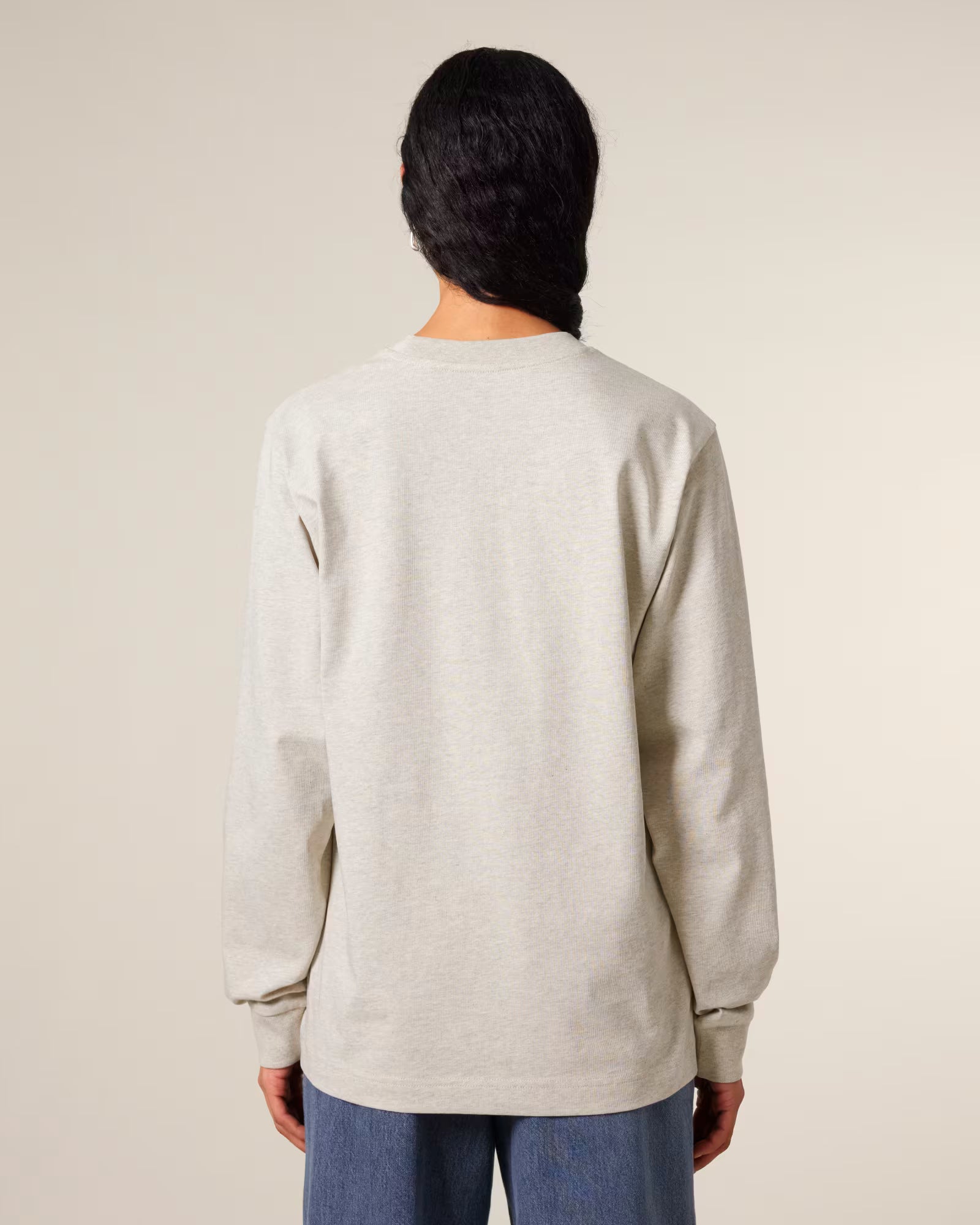 Back view of a male model wearing a light beige cotton long sleeve t-shirt in studio