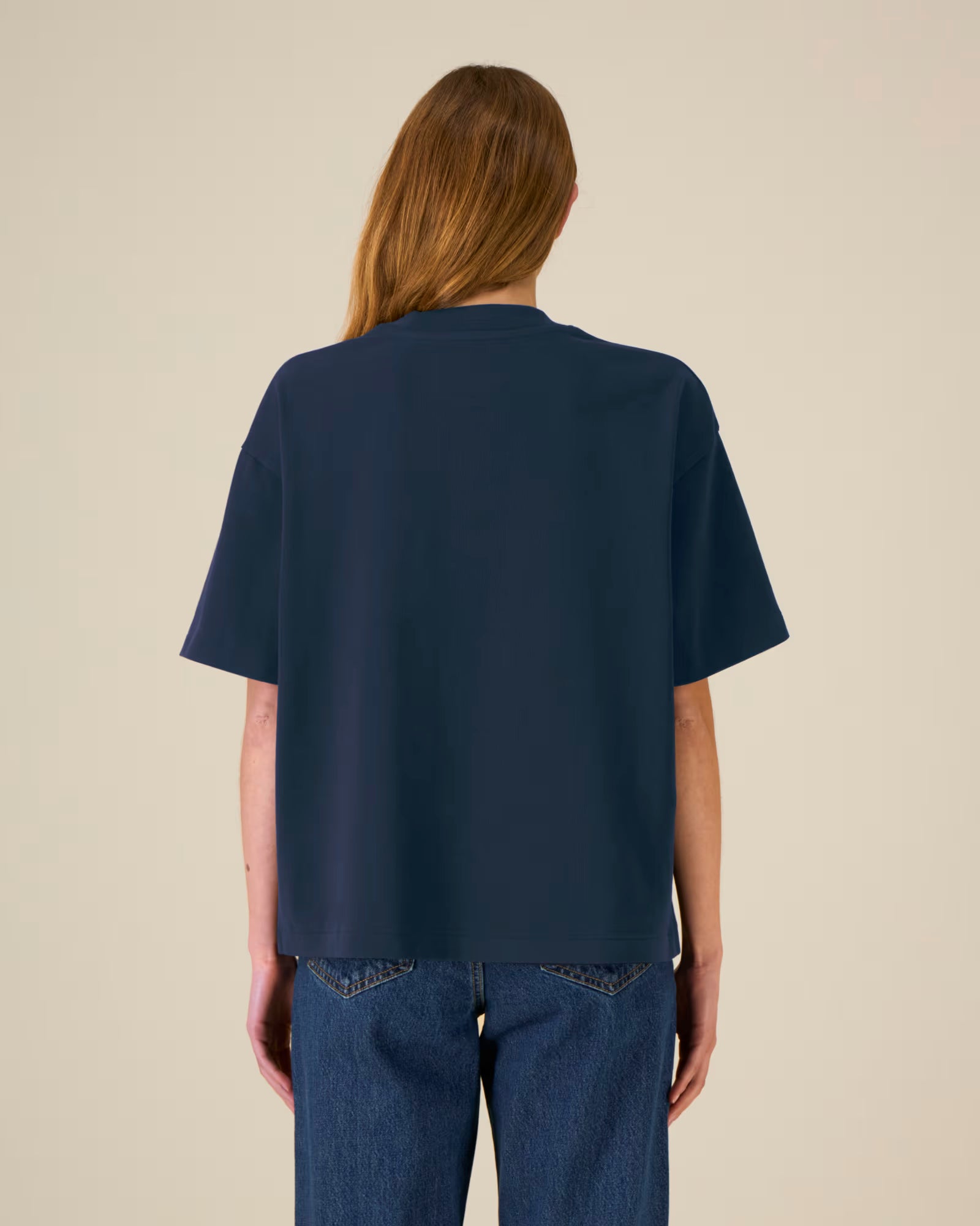 Back view of a model wearing a navy blue cotton t-shirt in studio