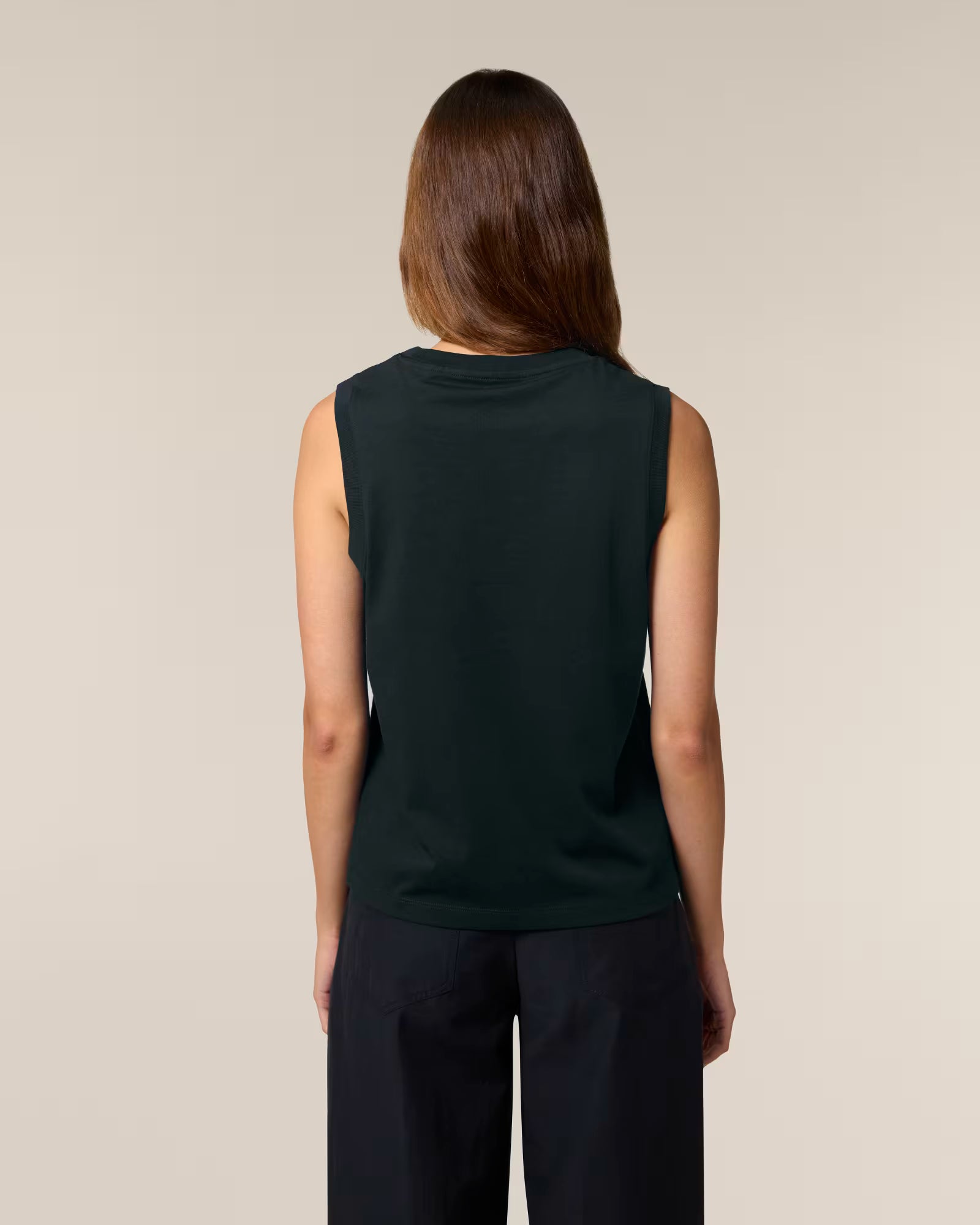Back view of a female model wearing a black cotton sleeveless top in studio