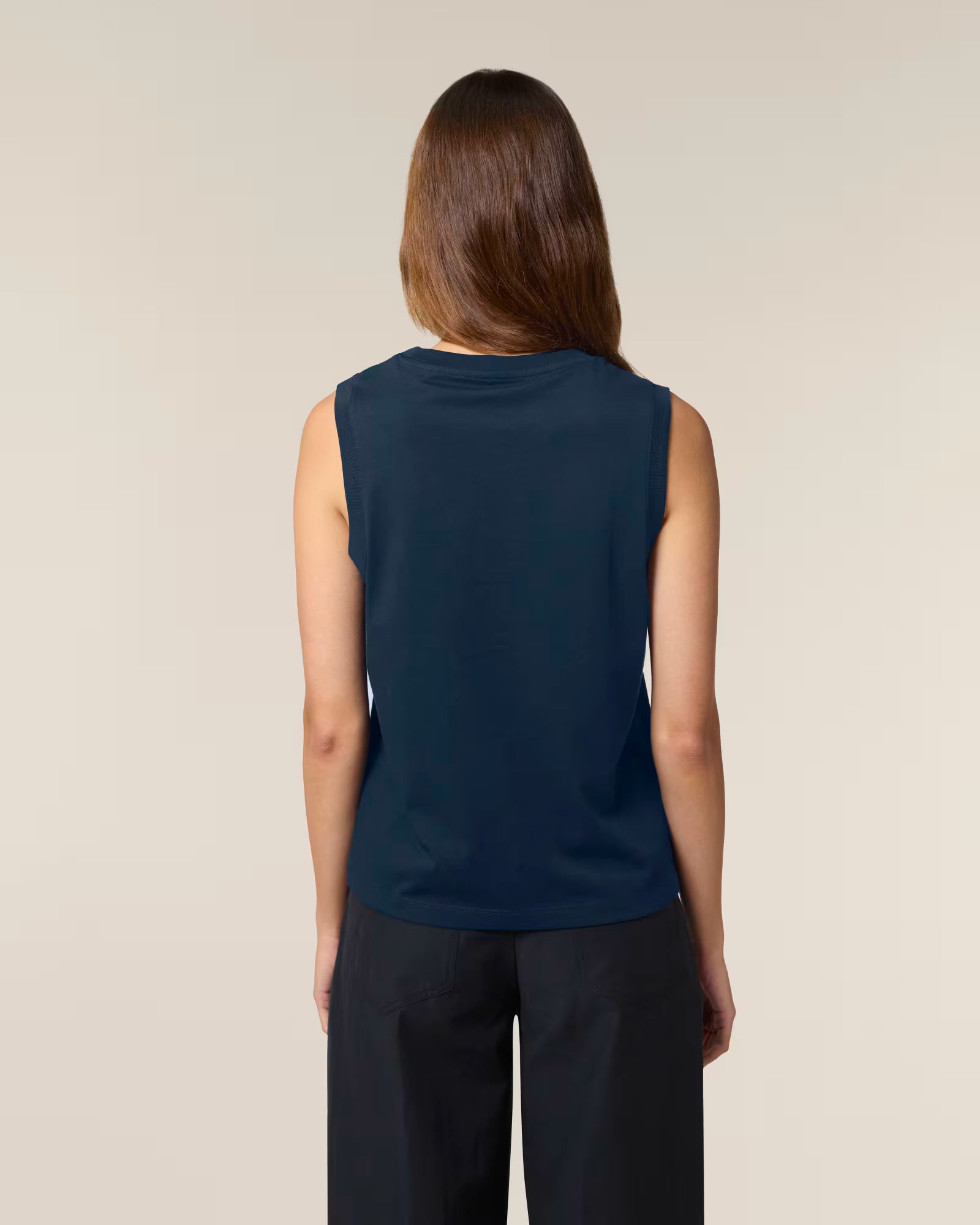 Back view of a female model wearing a navy cotton sleeveless top in studio
