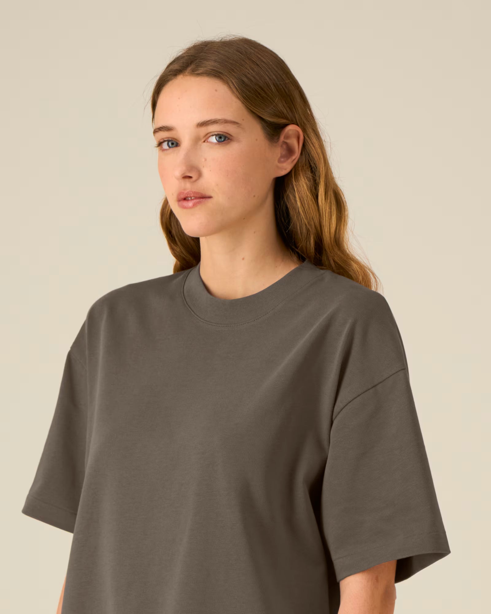 Front detail view of a female model wearing a brown cotton t-shirt in studio