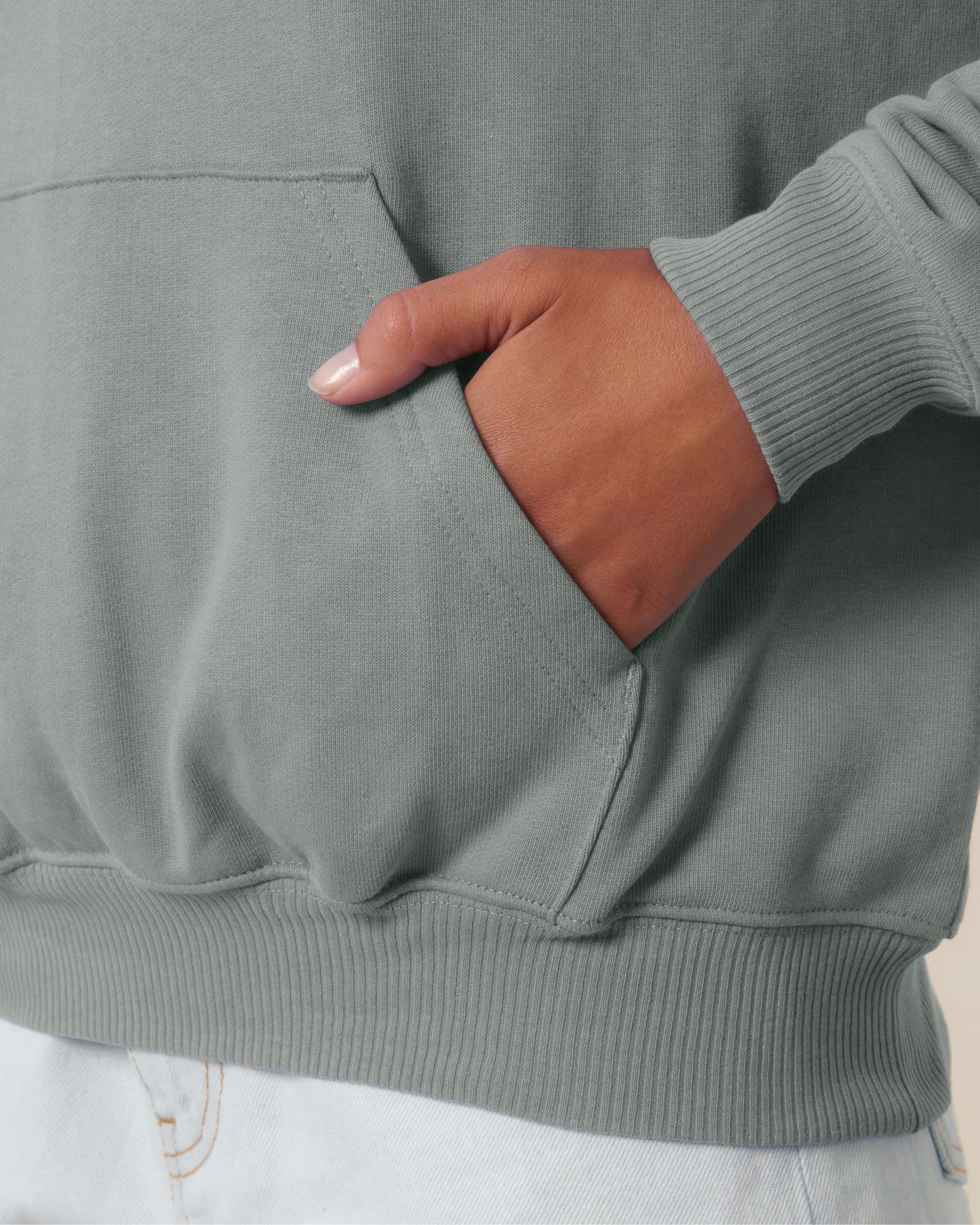 Close up detail of a sage green cotton hoodie sleeve in studio
