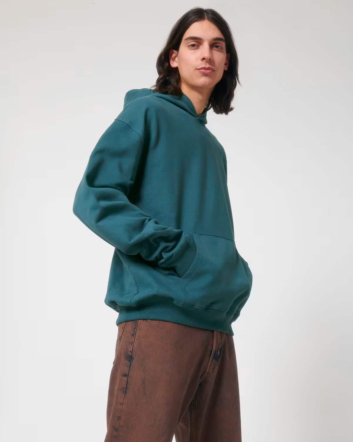 Front view of a male model wearing a teal cotton hoodie in studio