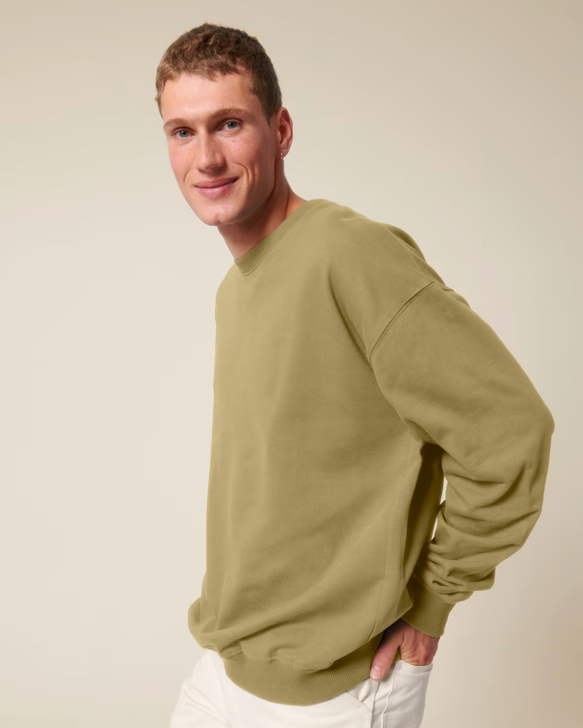 Front view of a male model wearing an olive green cotton hoodie in studio