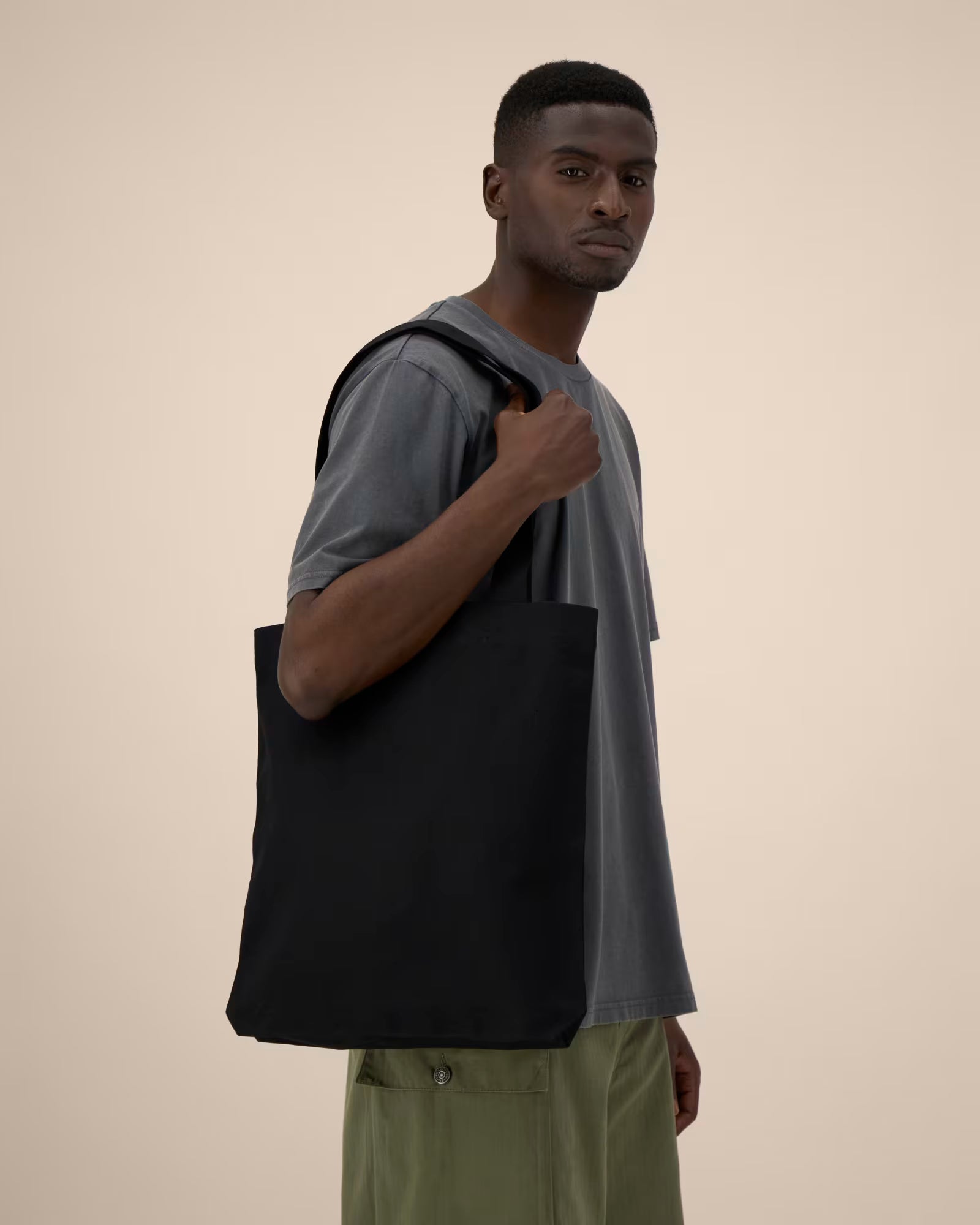 Black cotton tote bag side view on model