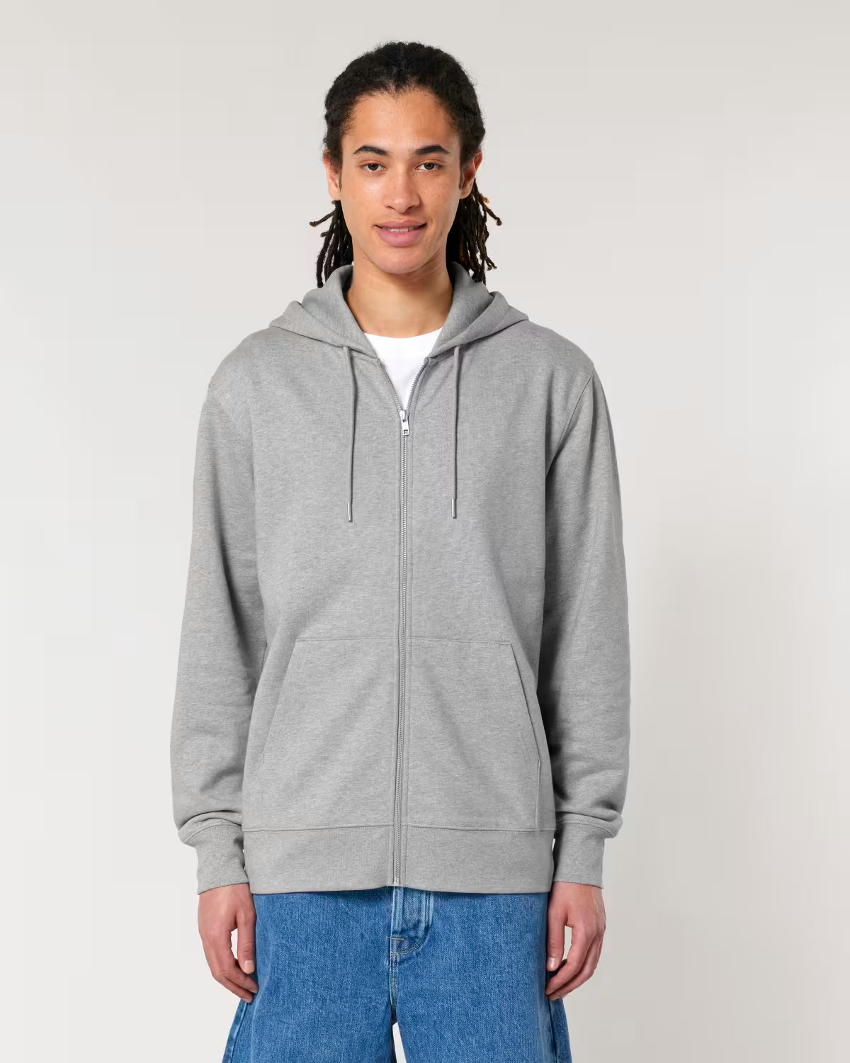 Person wearing a cotton gray hoodie and blue jeans on a plain background
