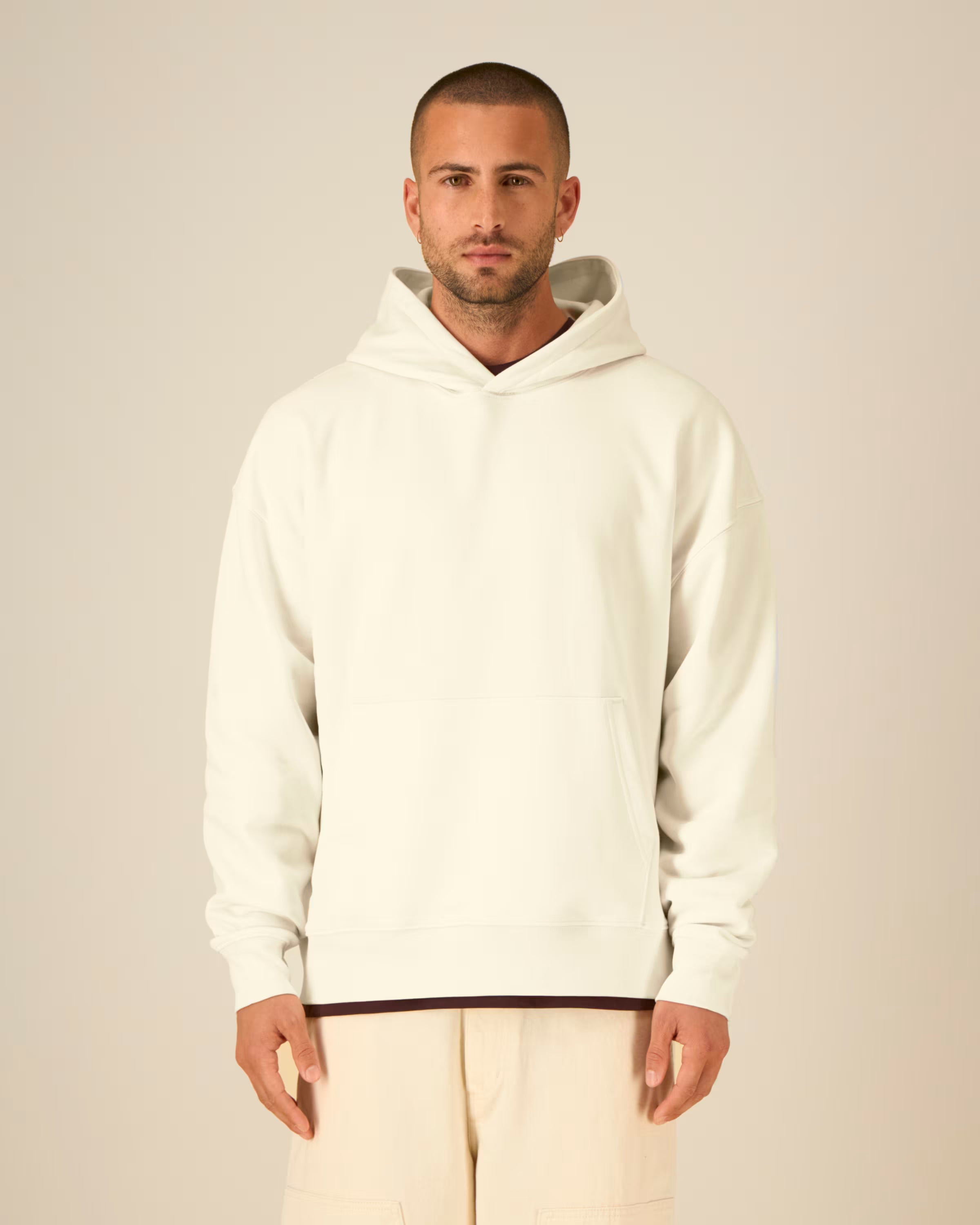 Man wearing a white unisex cotton hoodie against a plain background