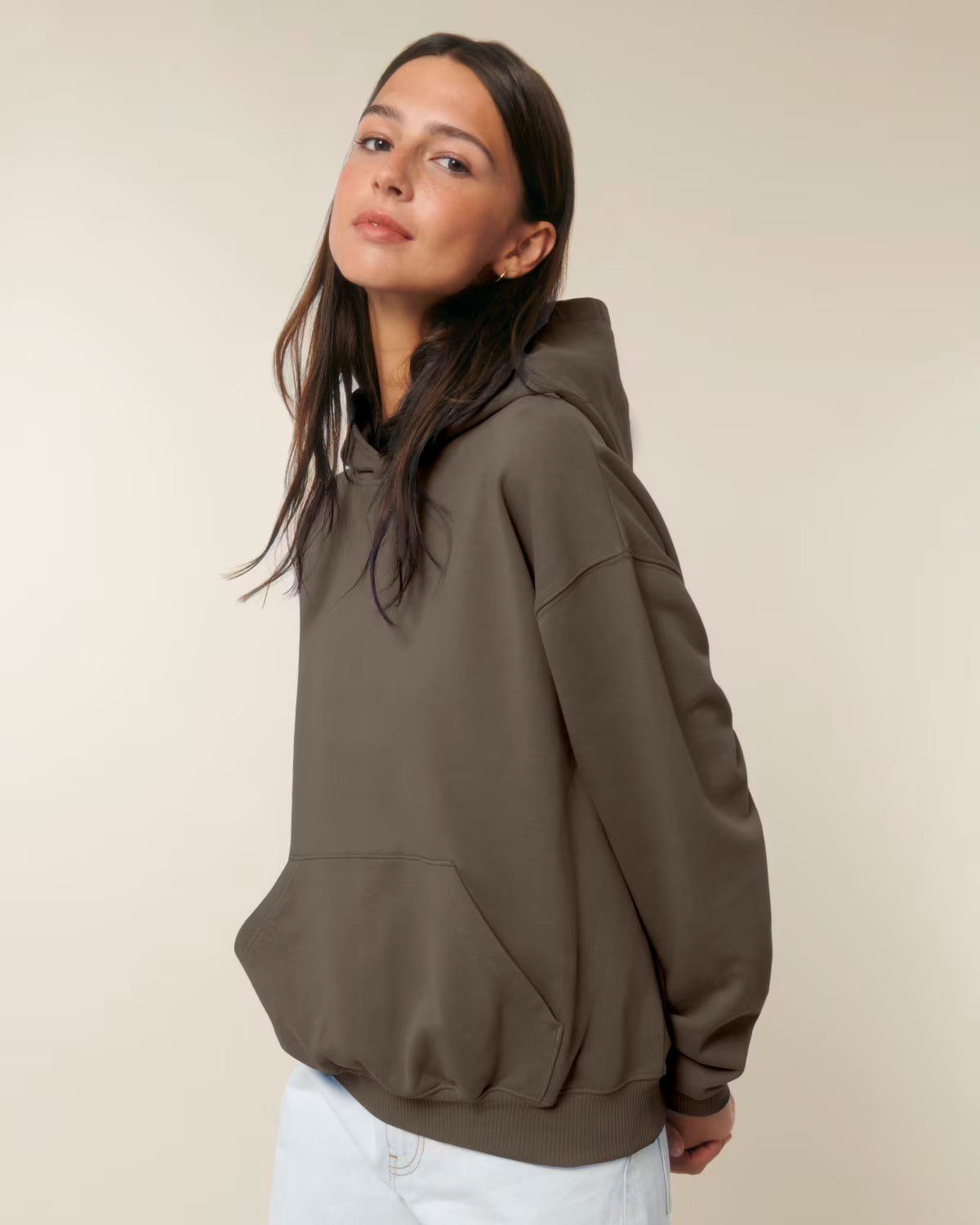 Front view of a female model wearing a brown cotton hoodie in studio
