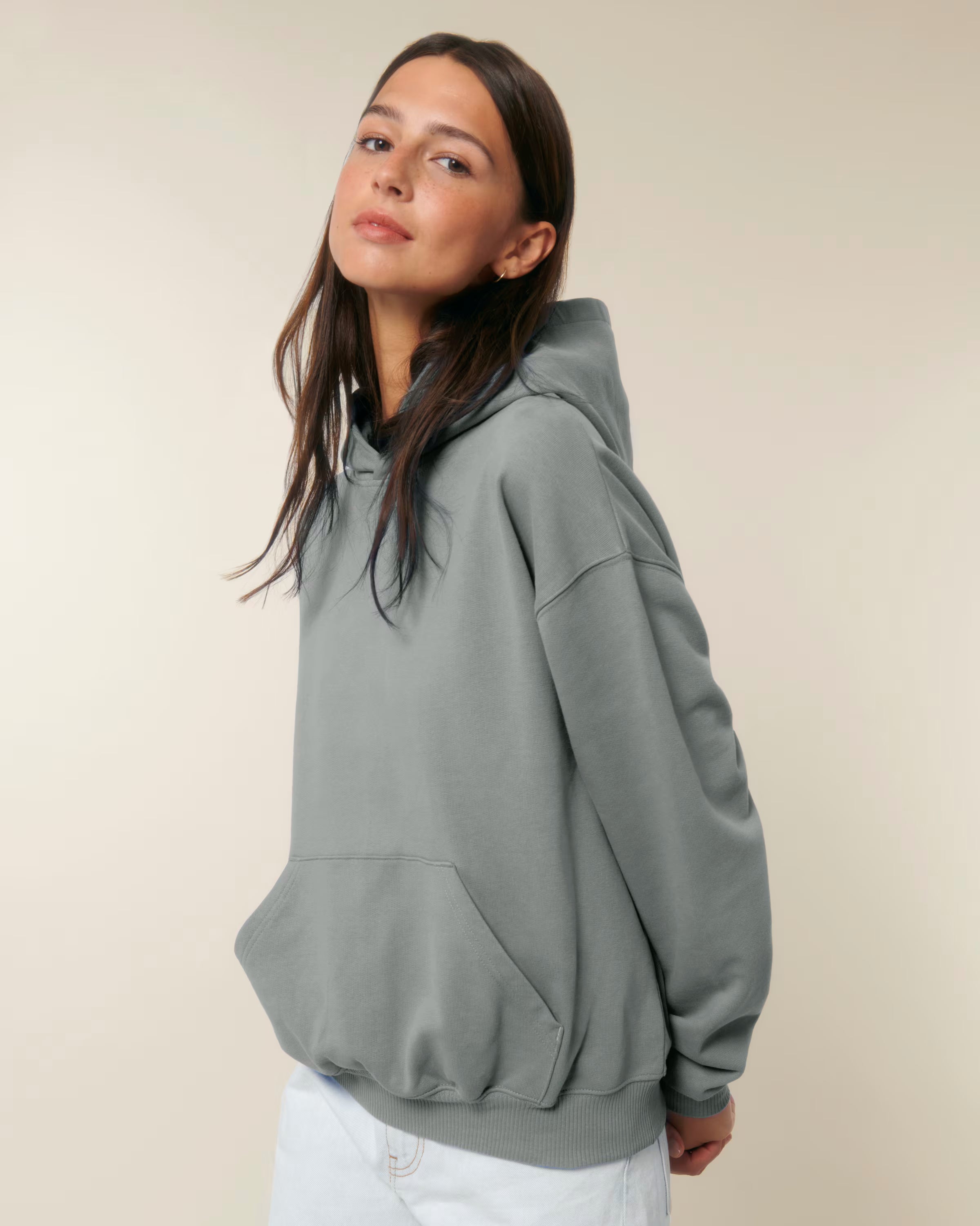 Person wearing a gray unisex cotton hoodie against a plain background