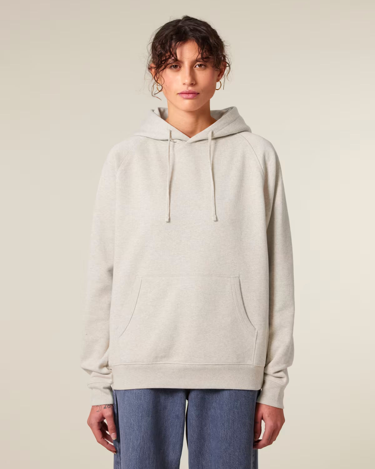 Front view of a male model wearing a beige cotton hoodie in studio