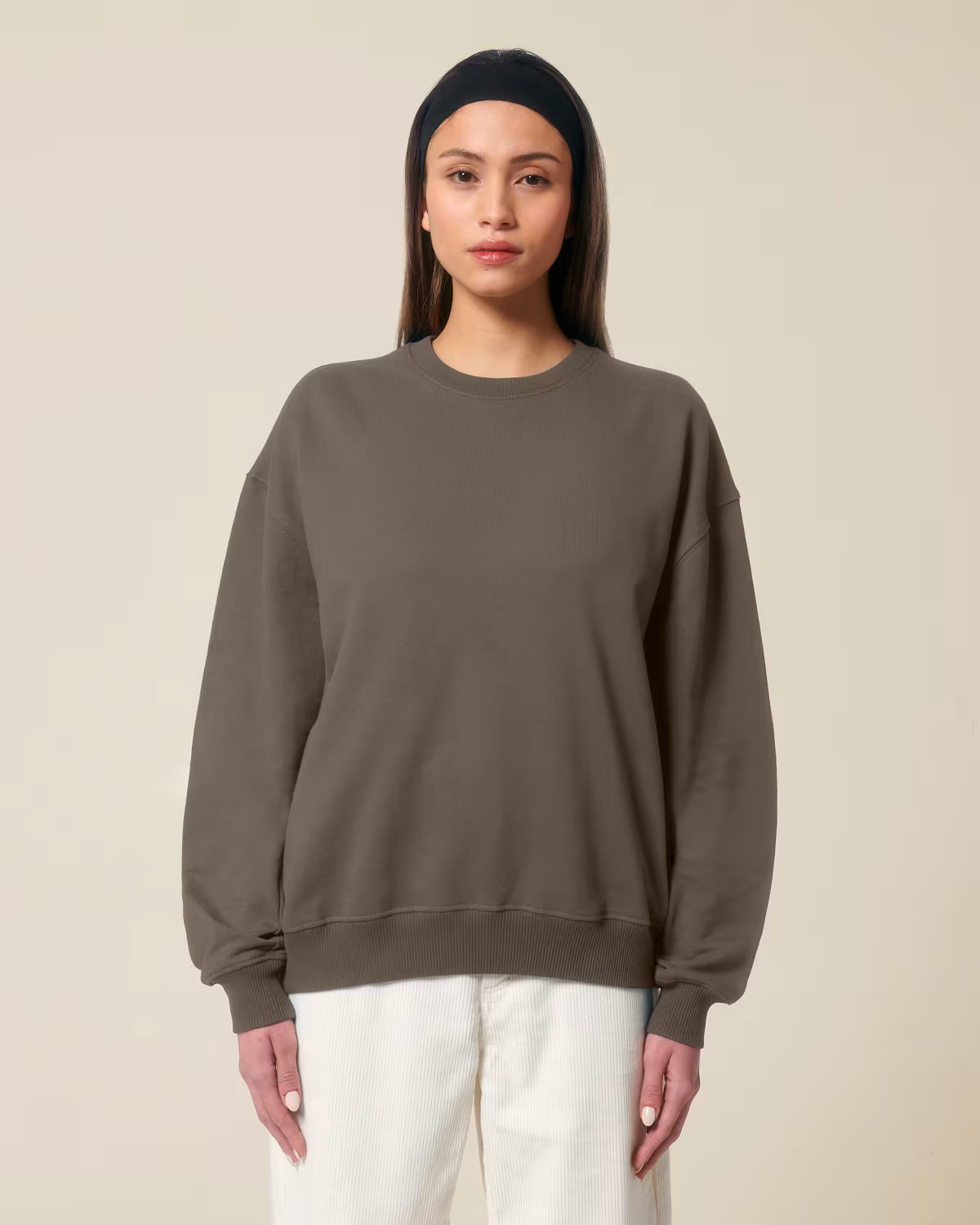 Front view of a female model wearing a brown cotton hoodie in studio