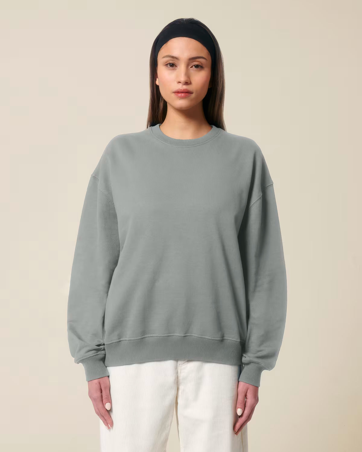 Front view of a female model wearing a grey cotton hoodie in studio