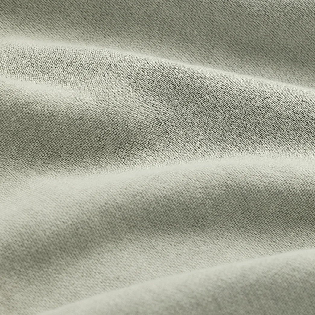 The Classic Crewneck sage green fabric texture close-up