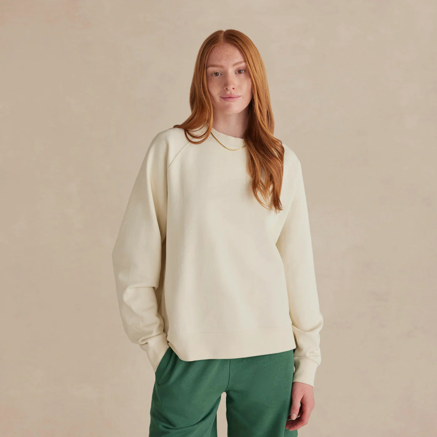 The Relaxed Crewneck cream sweatshirt worn by female model relaxed fit