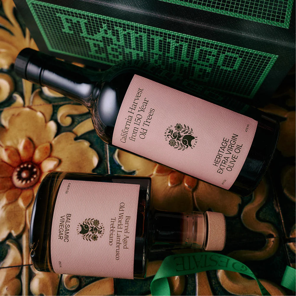 Flamingo Estate olive oil bottle flat lay with gourmet food, premium branded packaging