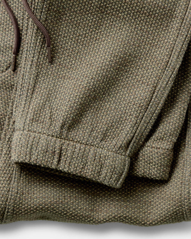 Cuffed hem detail on olive green jogger pants