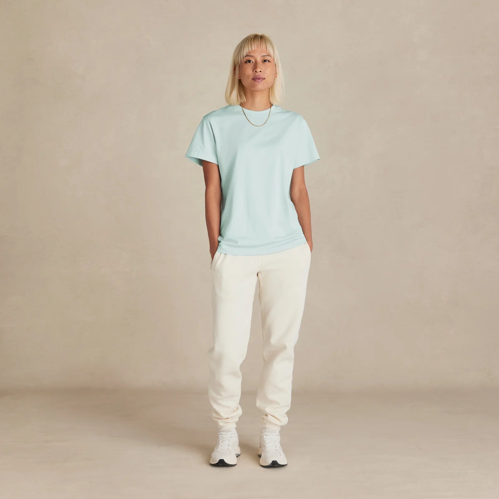The Essential Jogger cream sweatpants worn by female model