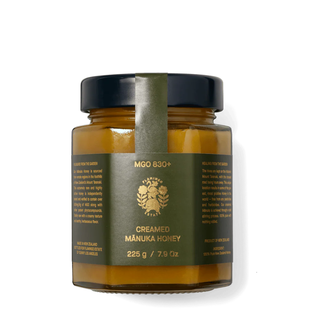 Jar of creamed manuka honey with a green label on a white background