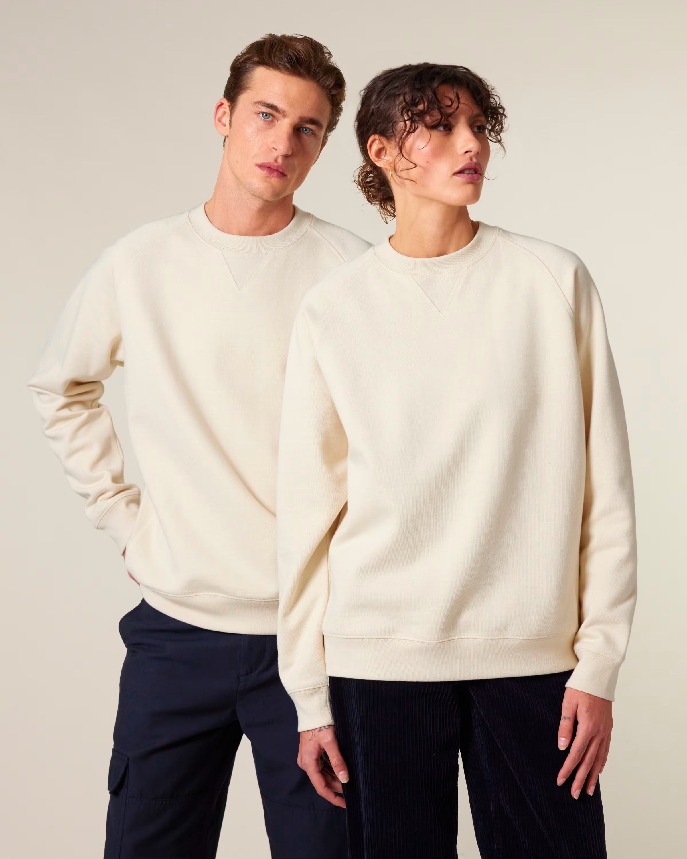 Front view of a beige unisex cotton hoodie worn by a model in studio, relaxed fit, suitable for customization and printing