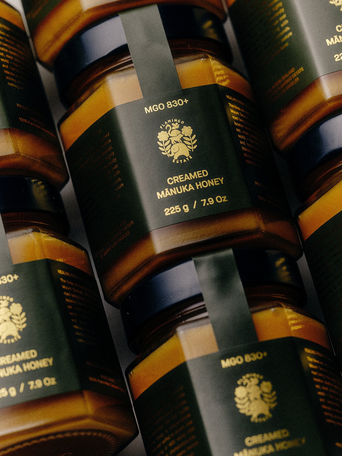 Jars of creamed Manuka honey with visible branding on a dark background