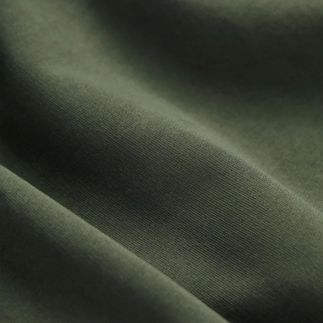 EMERCYN Essential Crewneck – forest green unisex sweatshirt styled in lifestyle look