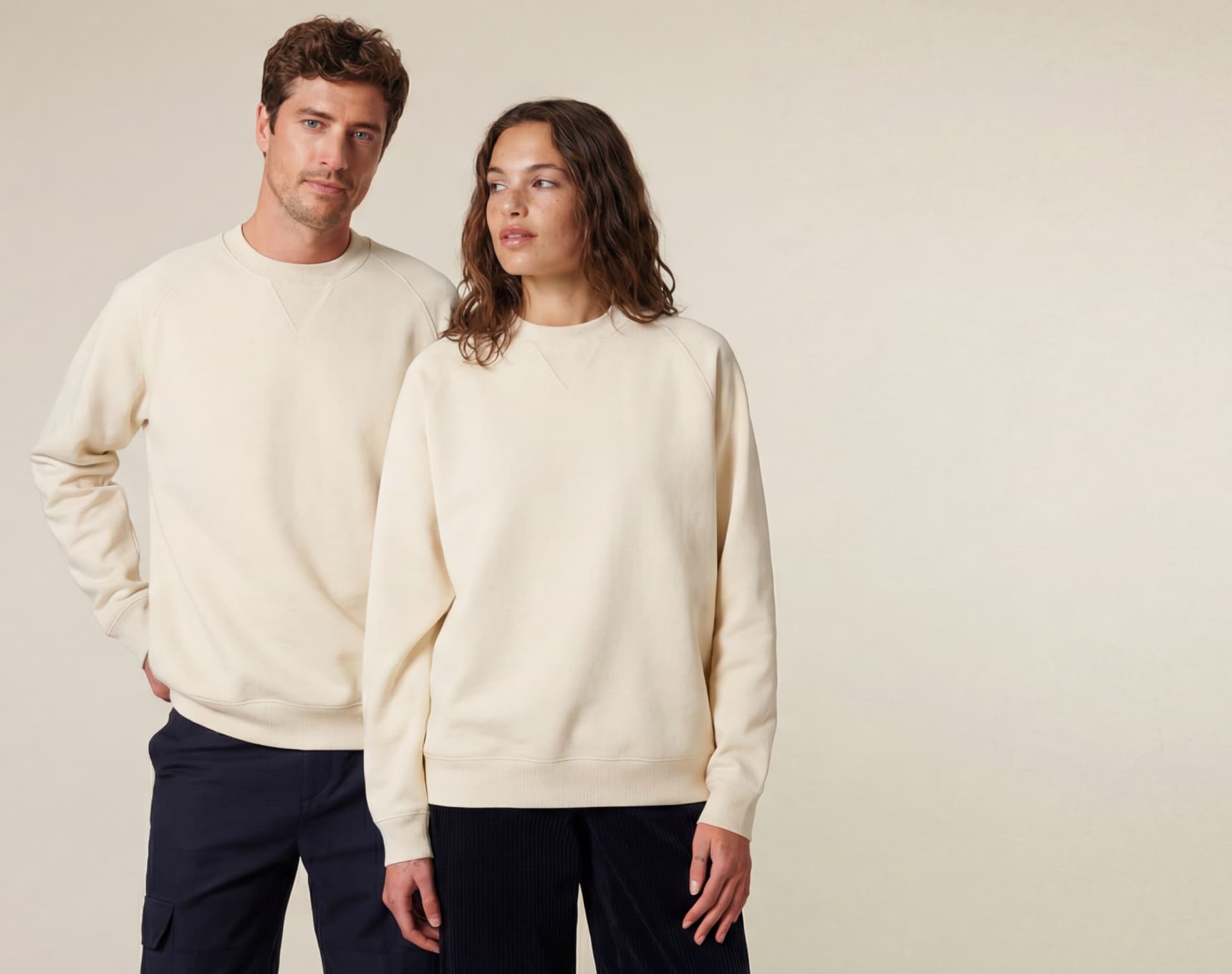 man and woman wearing neutral beige sweatshirts, unisex sustainable cotton apparel
