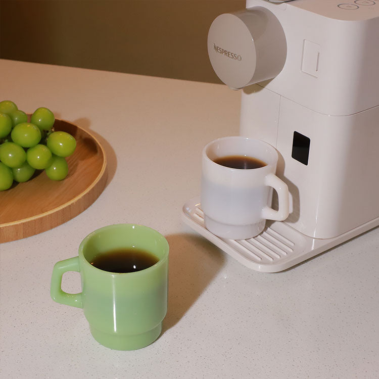 green and white ceramic mugs styled on table, custom branding options for merch