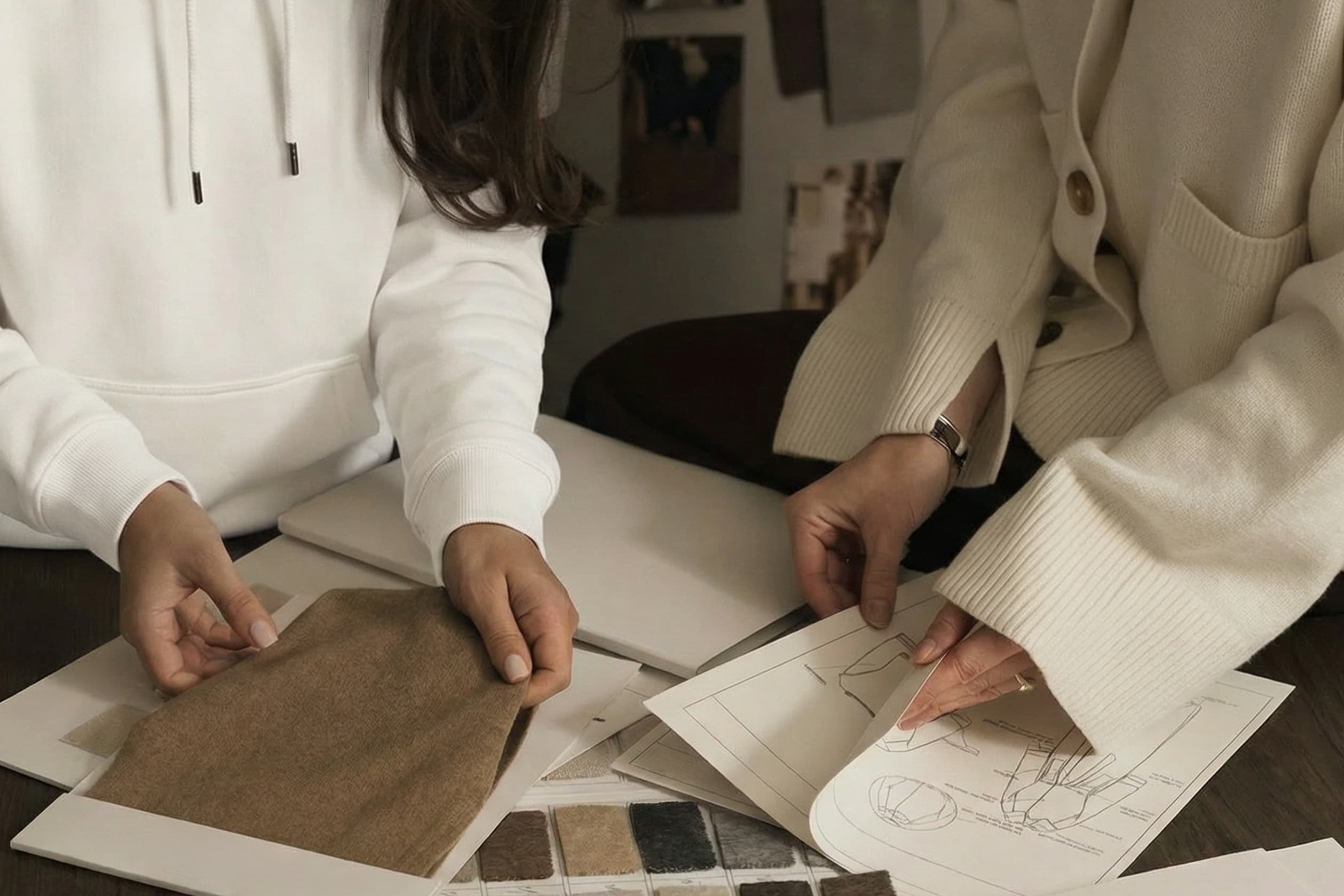 Two people examining color swatches and design papers on a table.