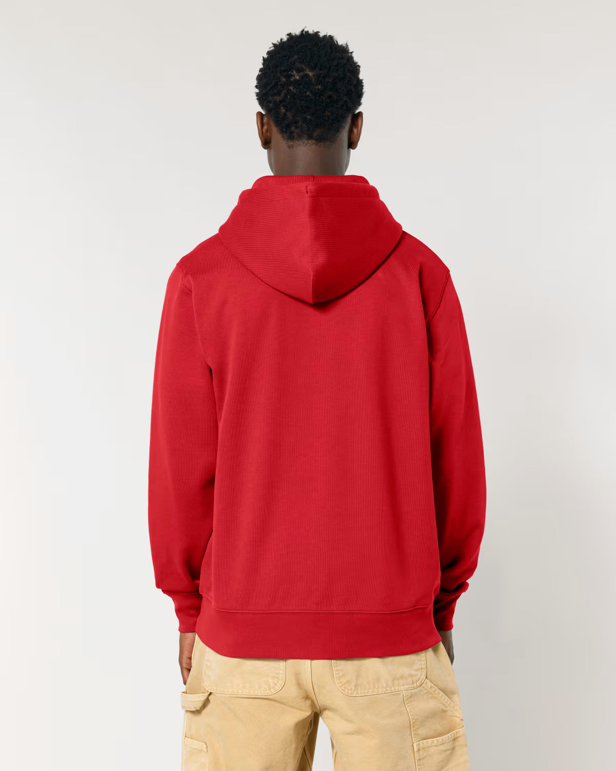 Person wearing a red cotton hoodie from behind on a plain background
