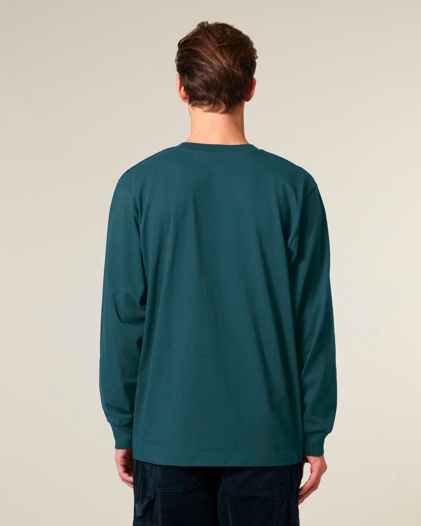 Back view of a male model wearing a teal green cotton long sleeve t-shirt in studio
