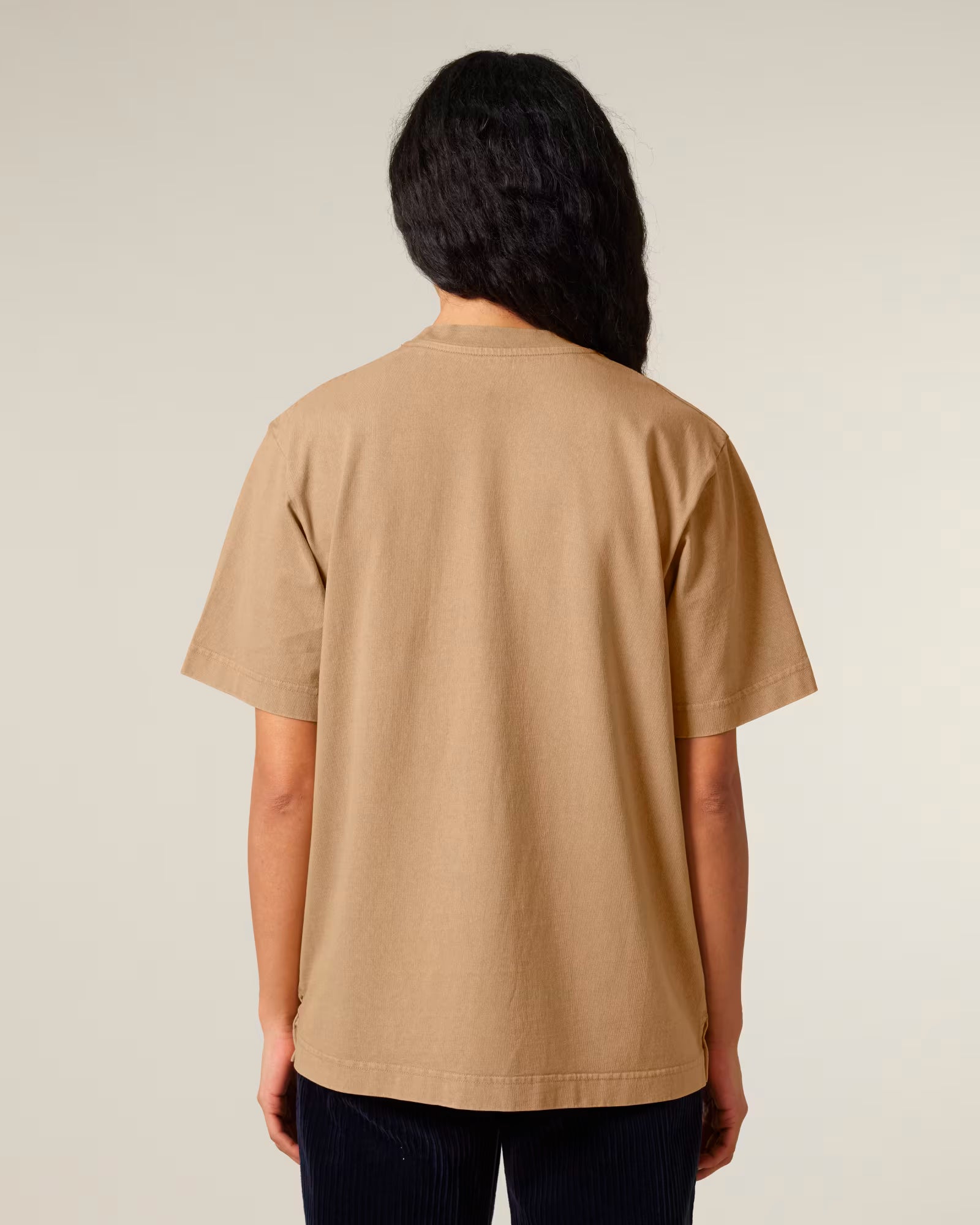 Back view of a model wearing a sand beige cotton t-shirt in studio