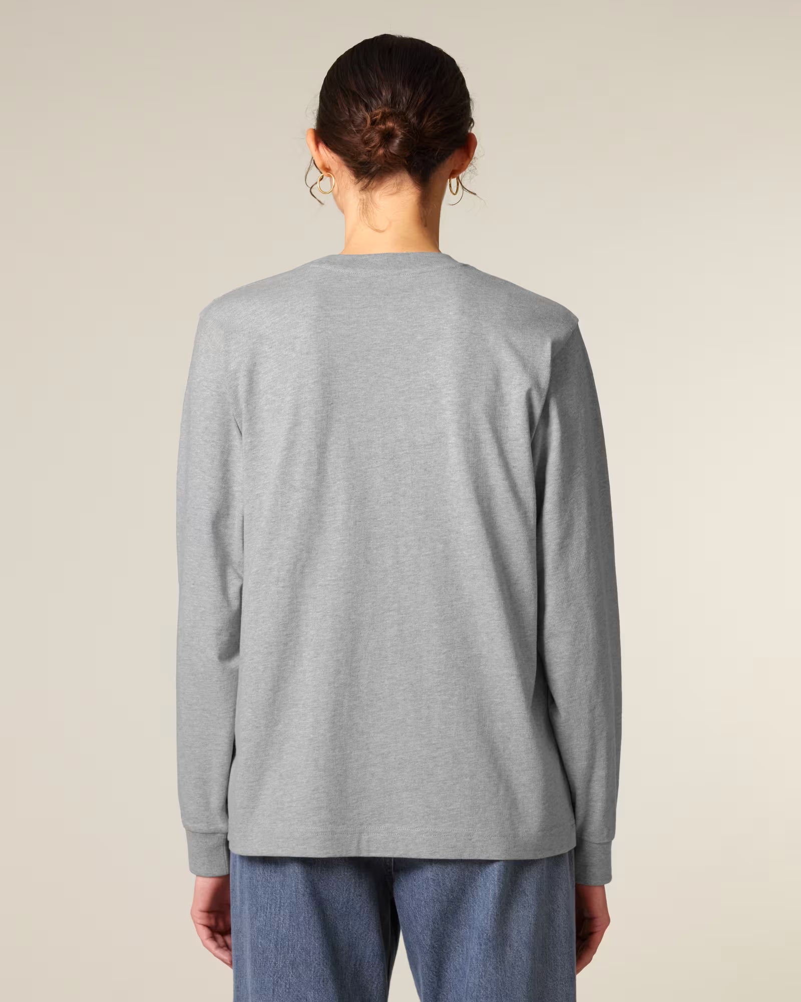 Back view of a male model wearing a light grey cotton long sleeve t-shirt in studio