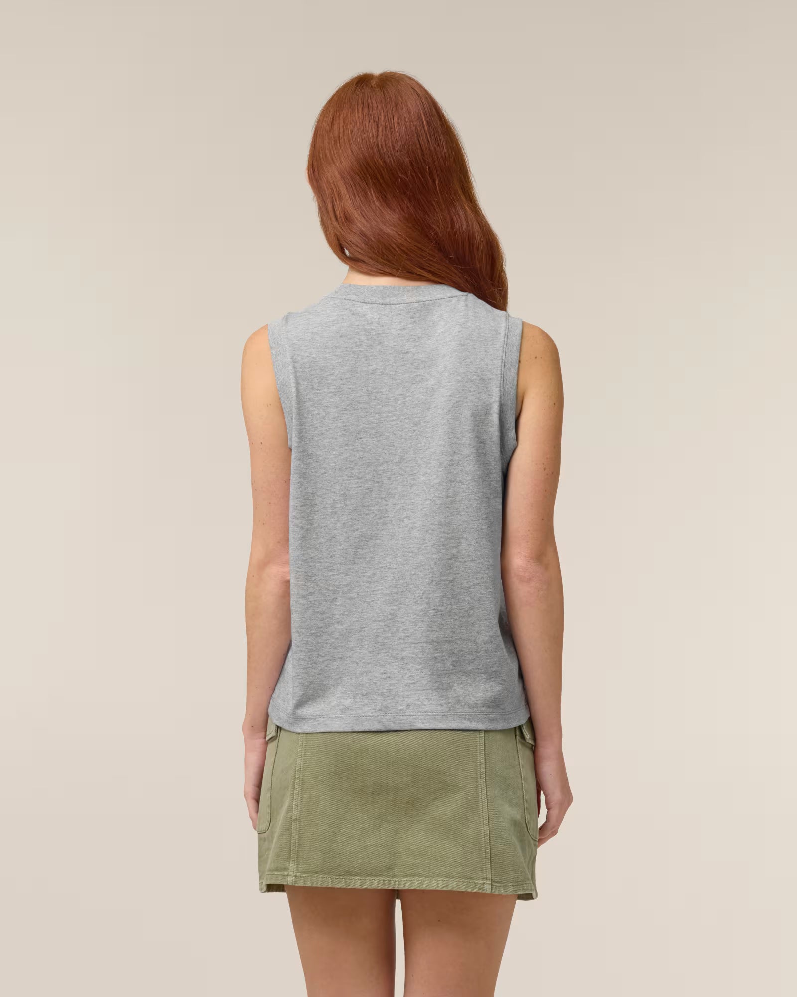 Back view of a female model wearing a light grey cotton sleeveless top in studio