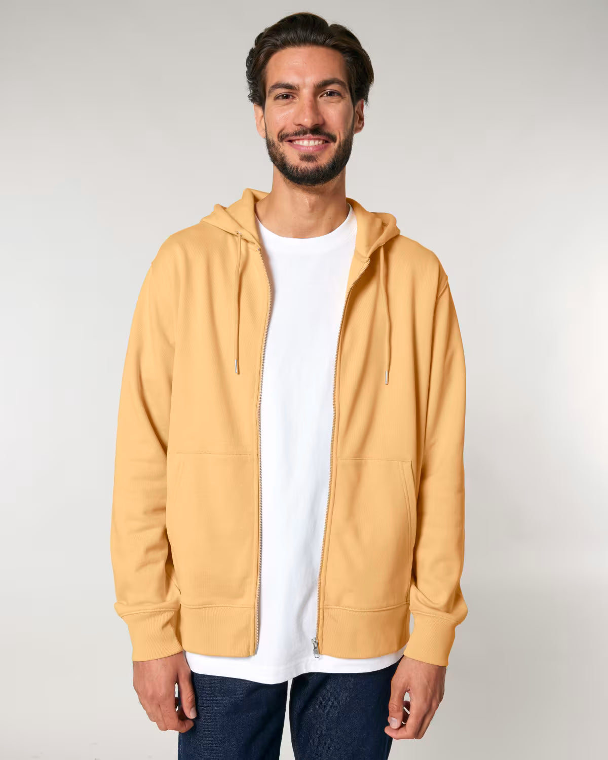 Man wearing a cotton mustard yellow hoodie over a white shirt on a plain background