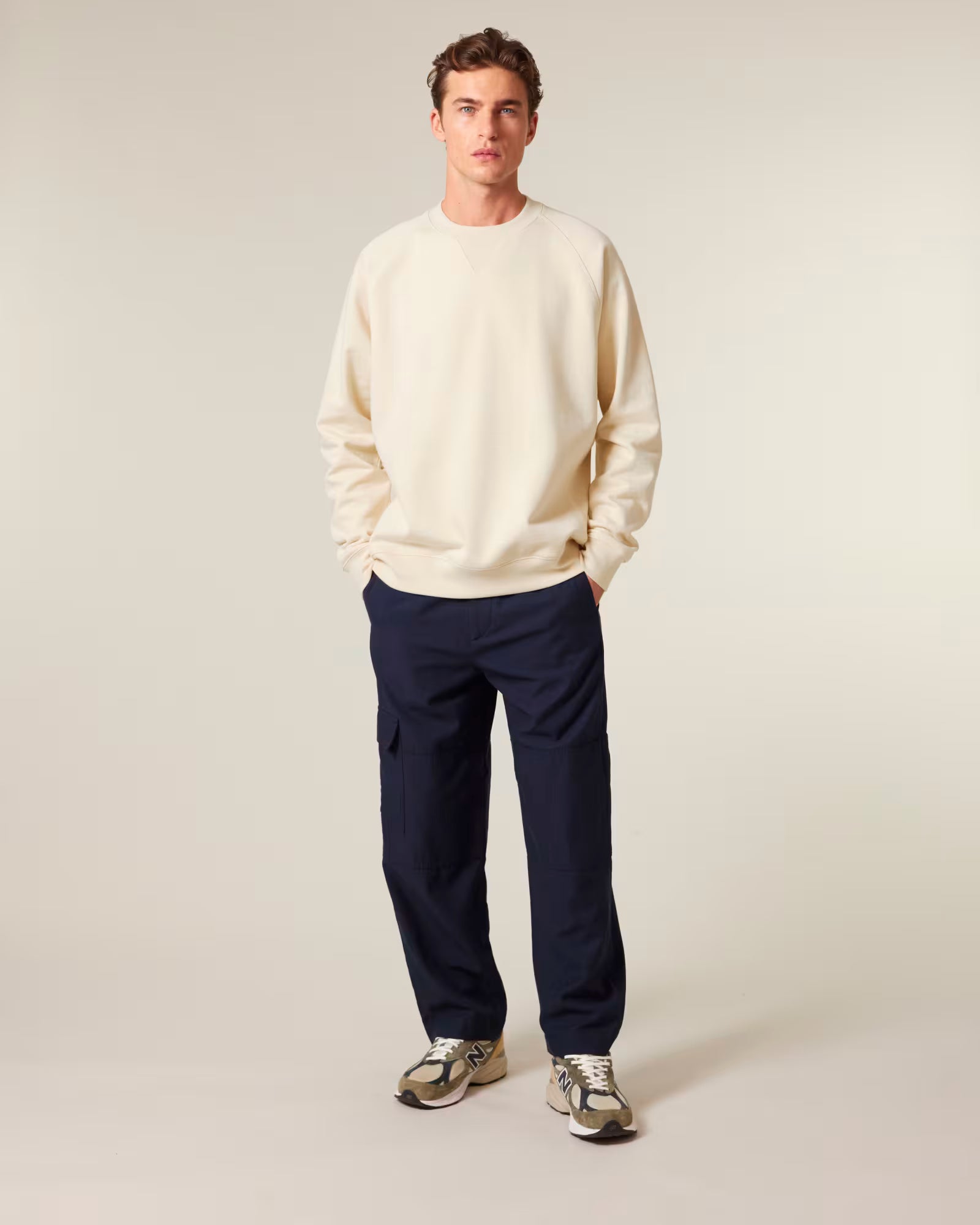 Front view of a male model wearing a beige cotton sweatshirt in studio