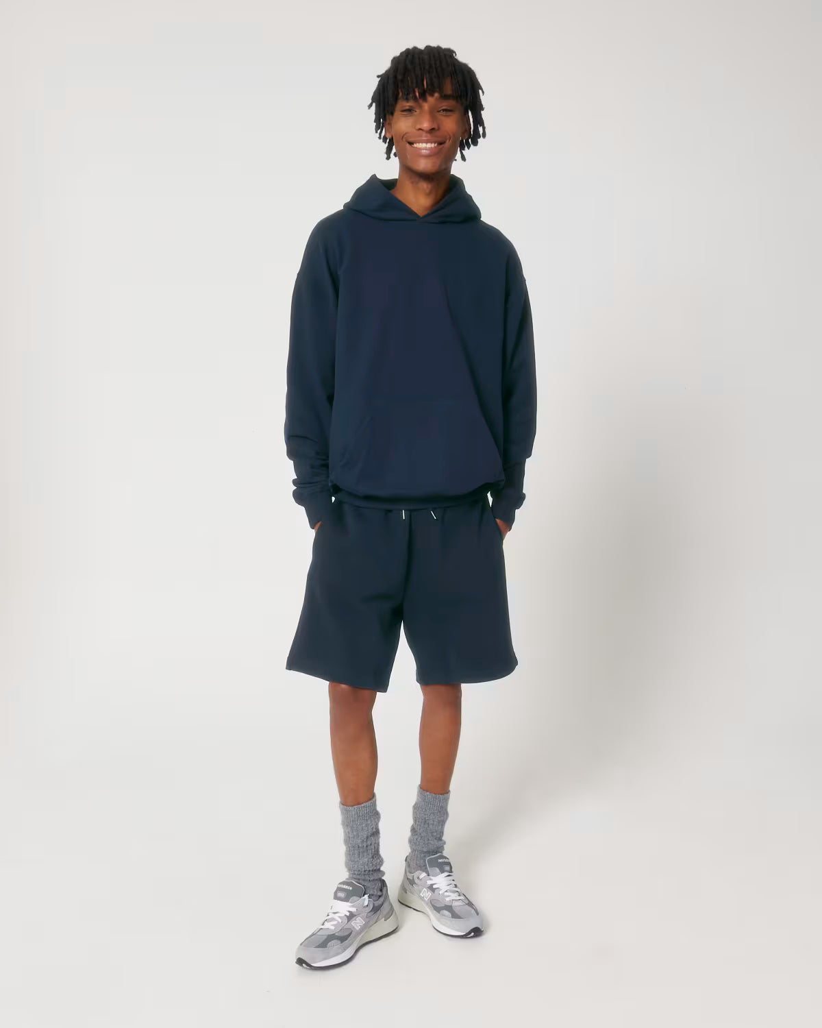 Full body back view of a female model wearing a navy cotton hoodie in studio