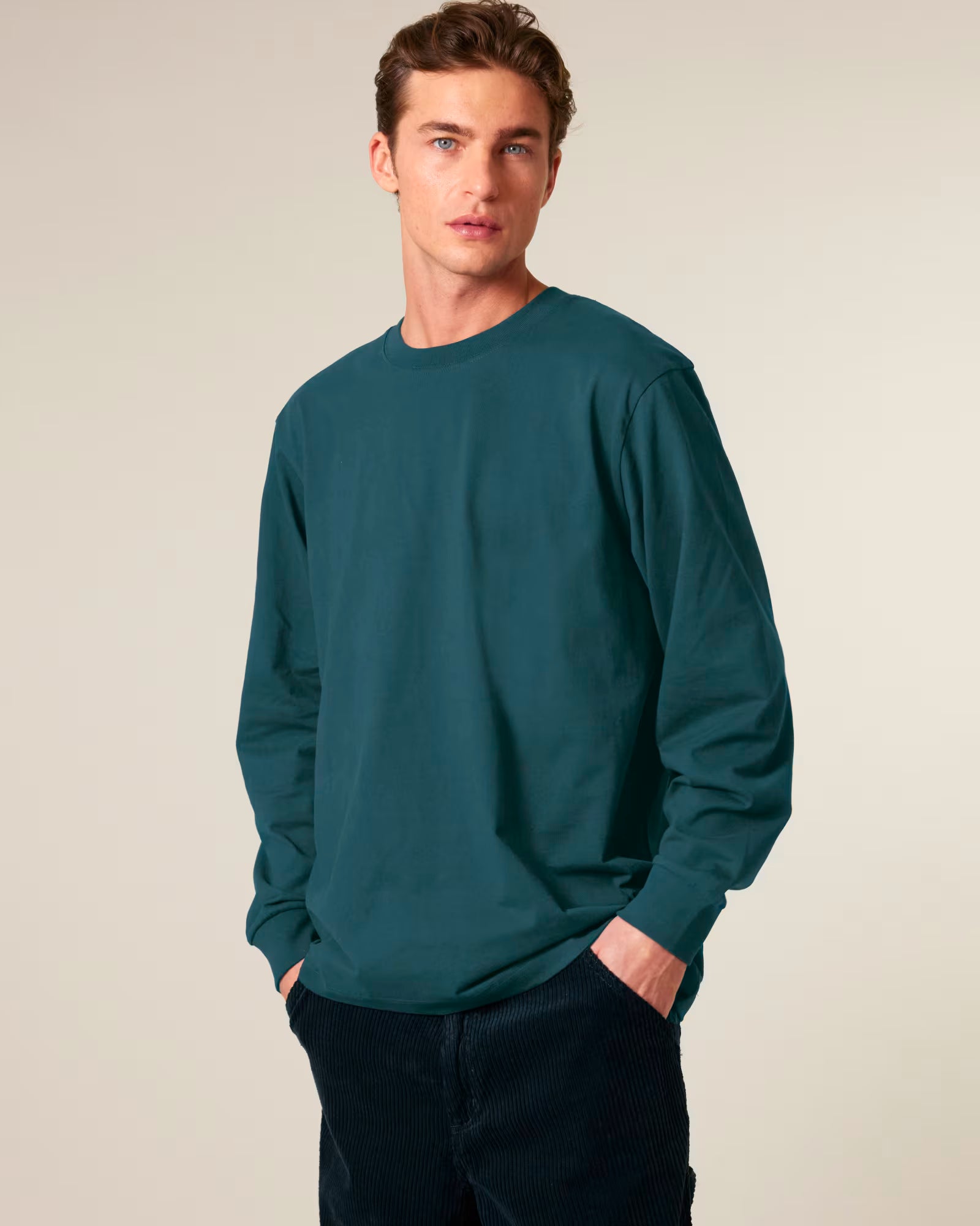 Front view of a male model wearing a teal green cotton long sleeve t-shirt in studio