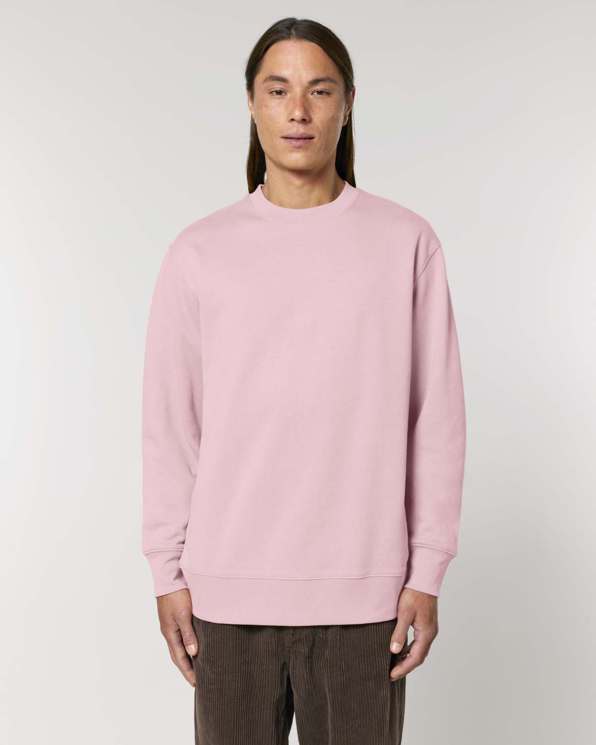 Person wearing a pink unisex cotton sweatshirt against a plain background