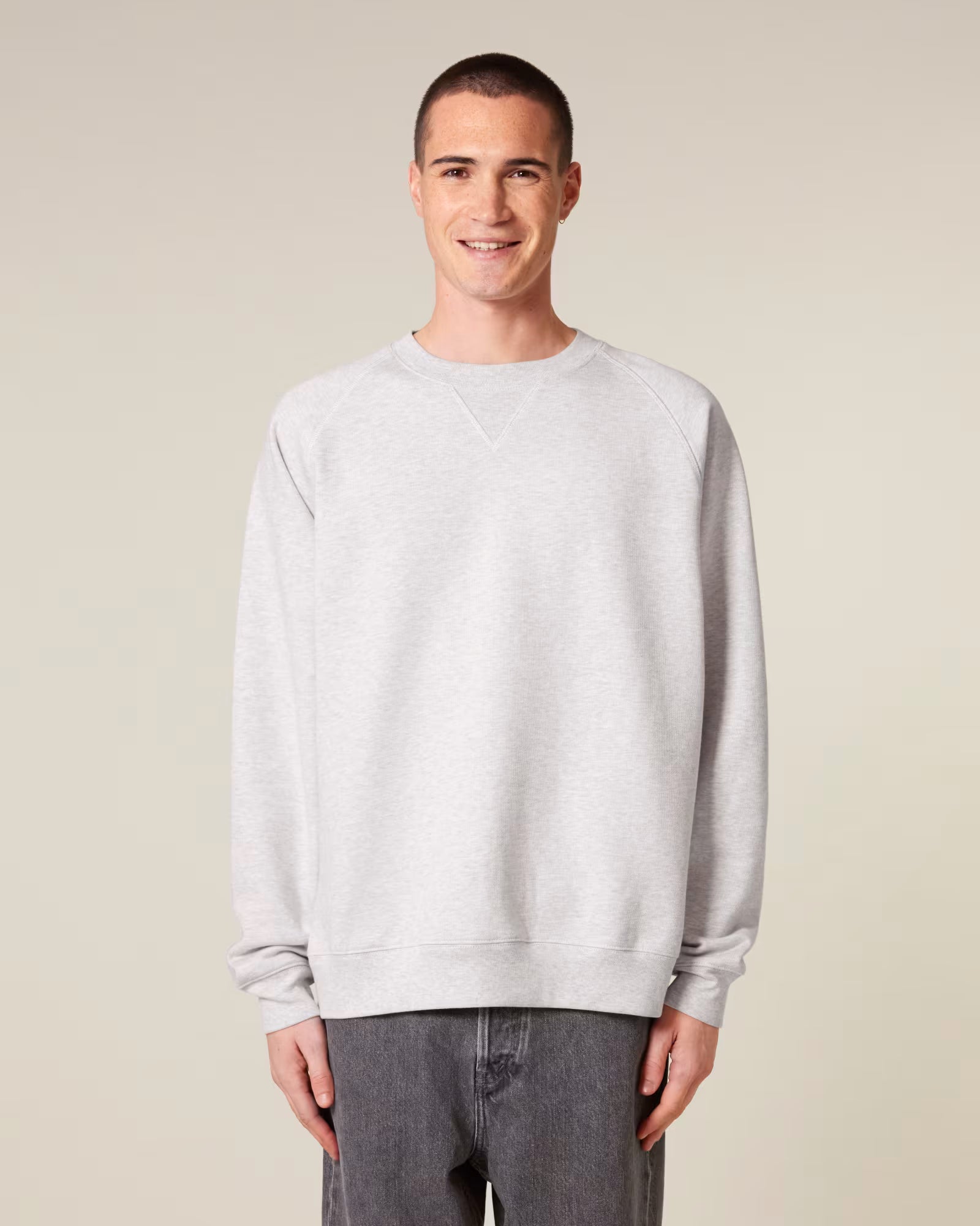 Front view of a male model wearing a white cotton sweatshirt in studio