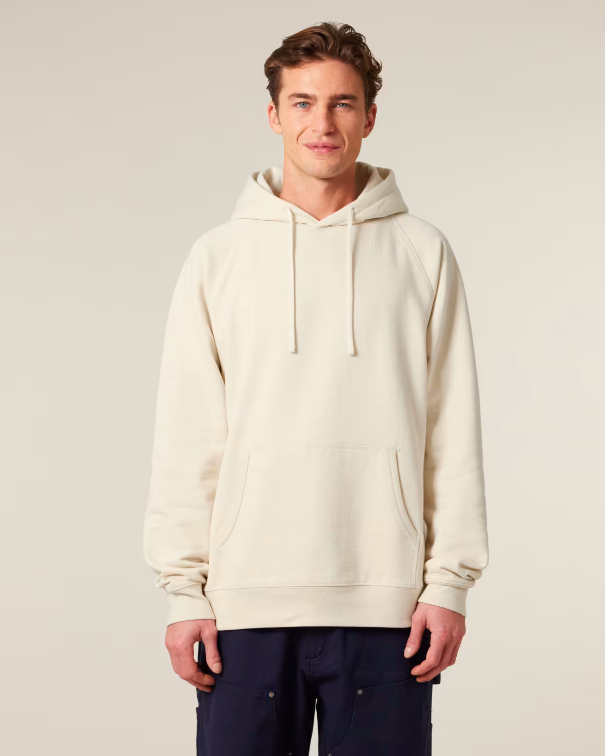 Front view of a man model wearing a beige orange cotton hoodie in studio
