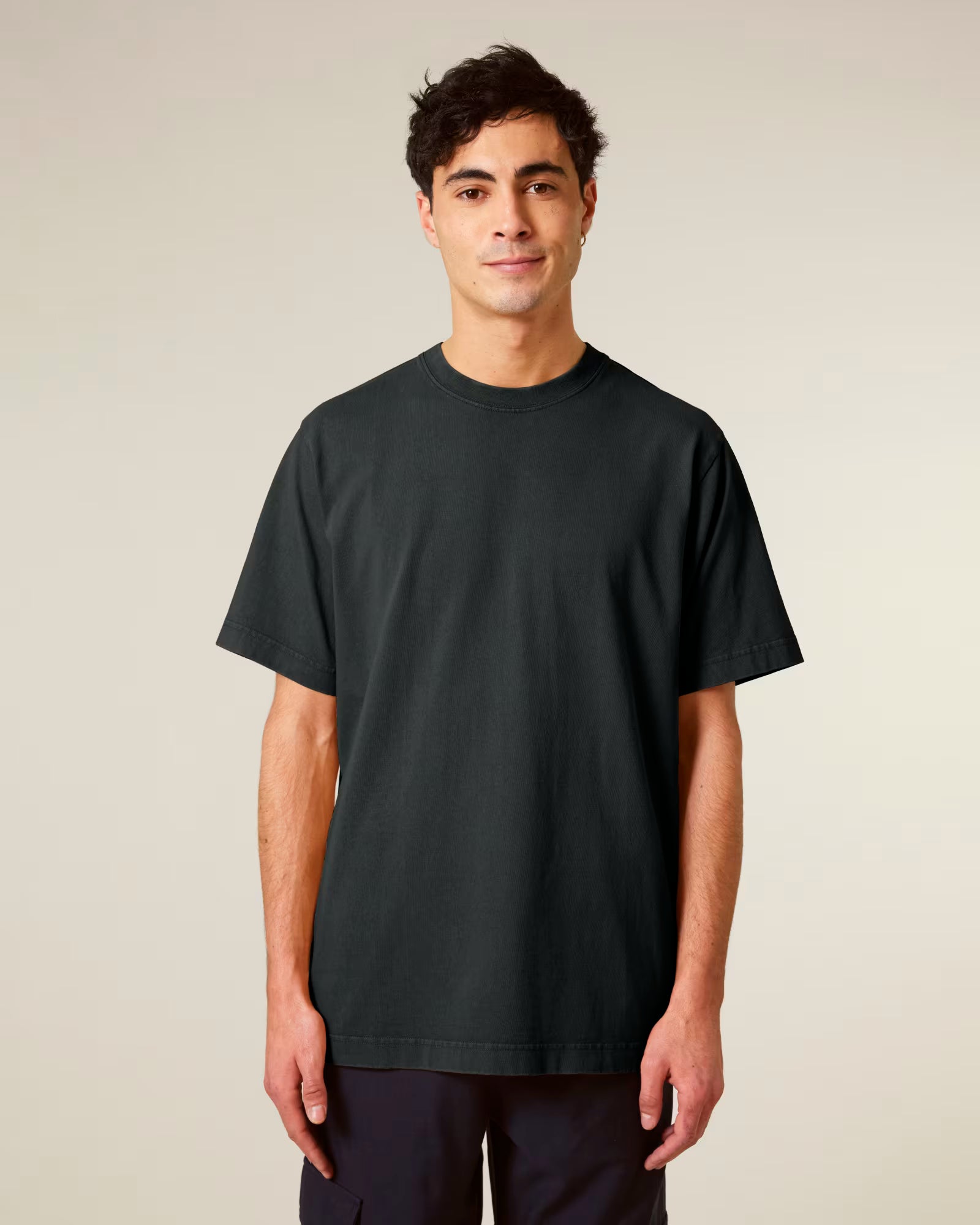 Front view of a man wearing a dark green cotton t-shirt against neutral studio background