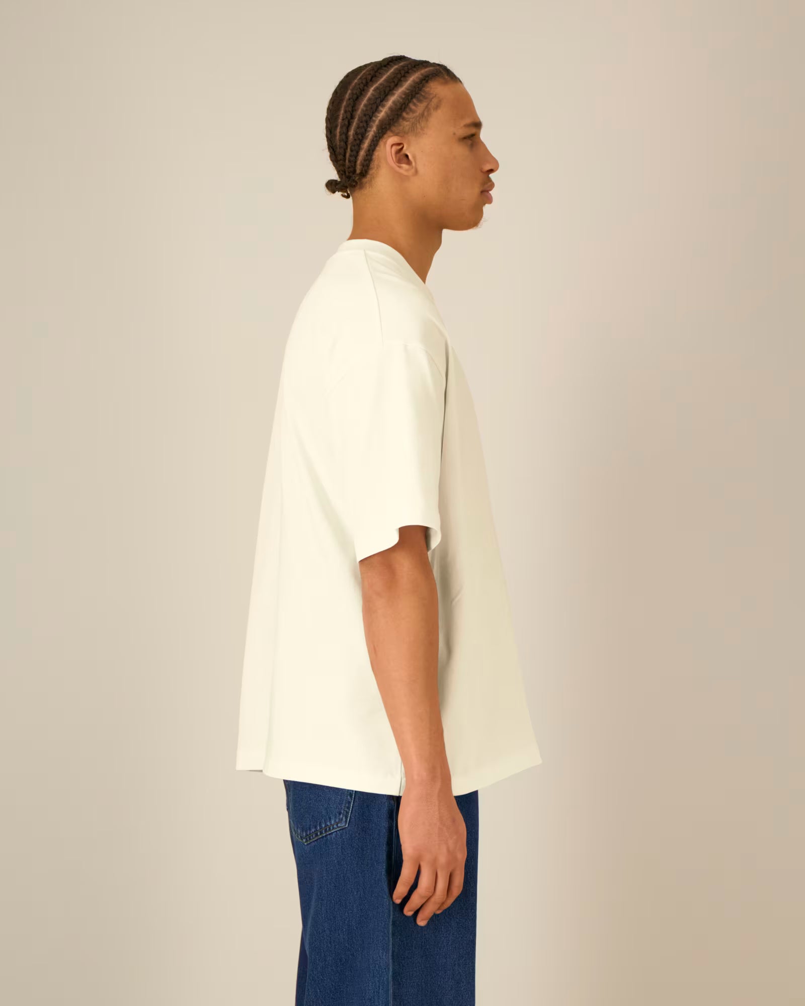 Side view of a female model wearing a natural beige cotton t-shirt in studio