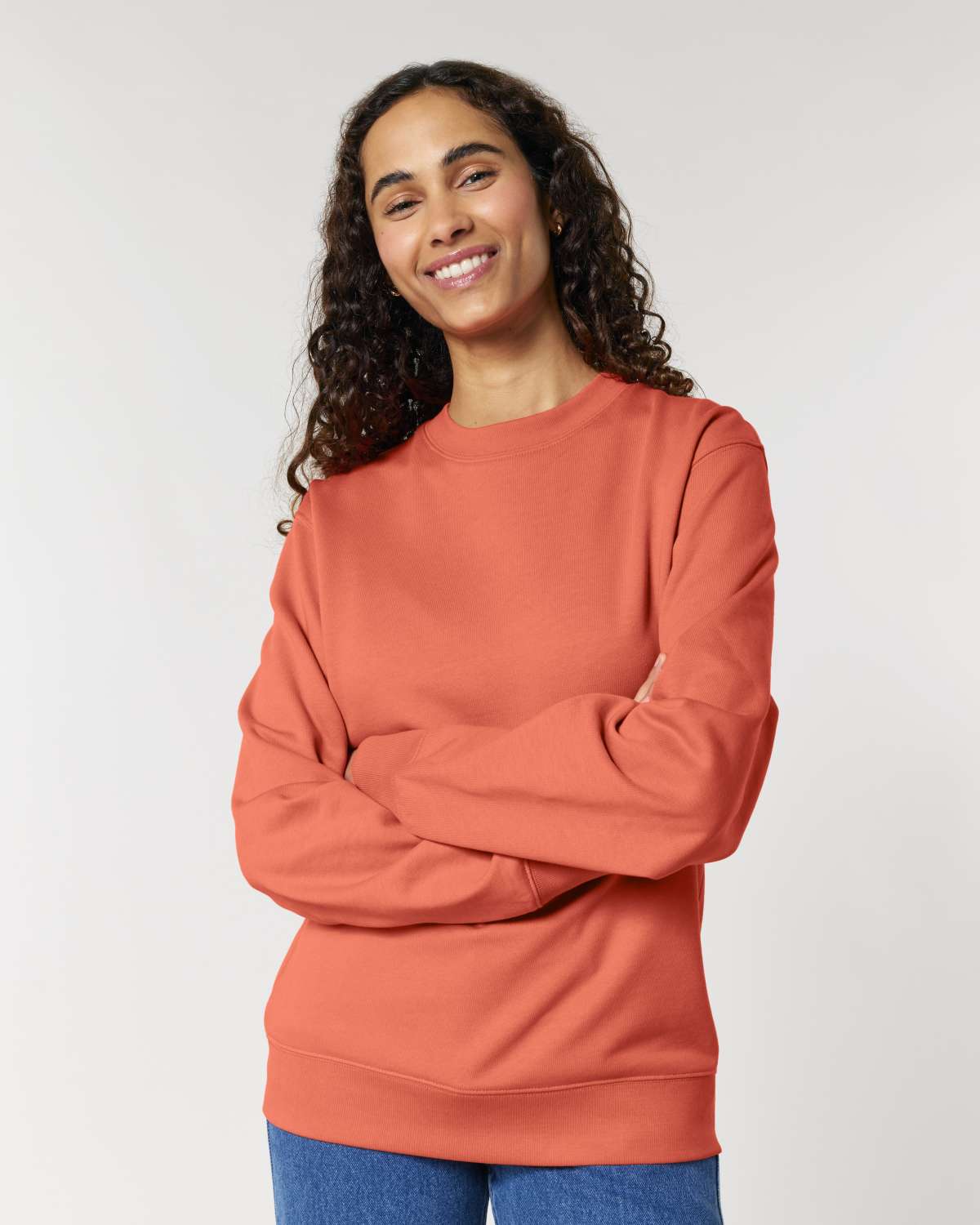Woman wearing a terracotta-colored unisex cotton hoodie isolated on white background