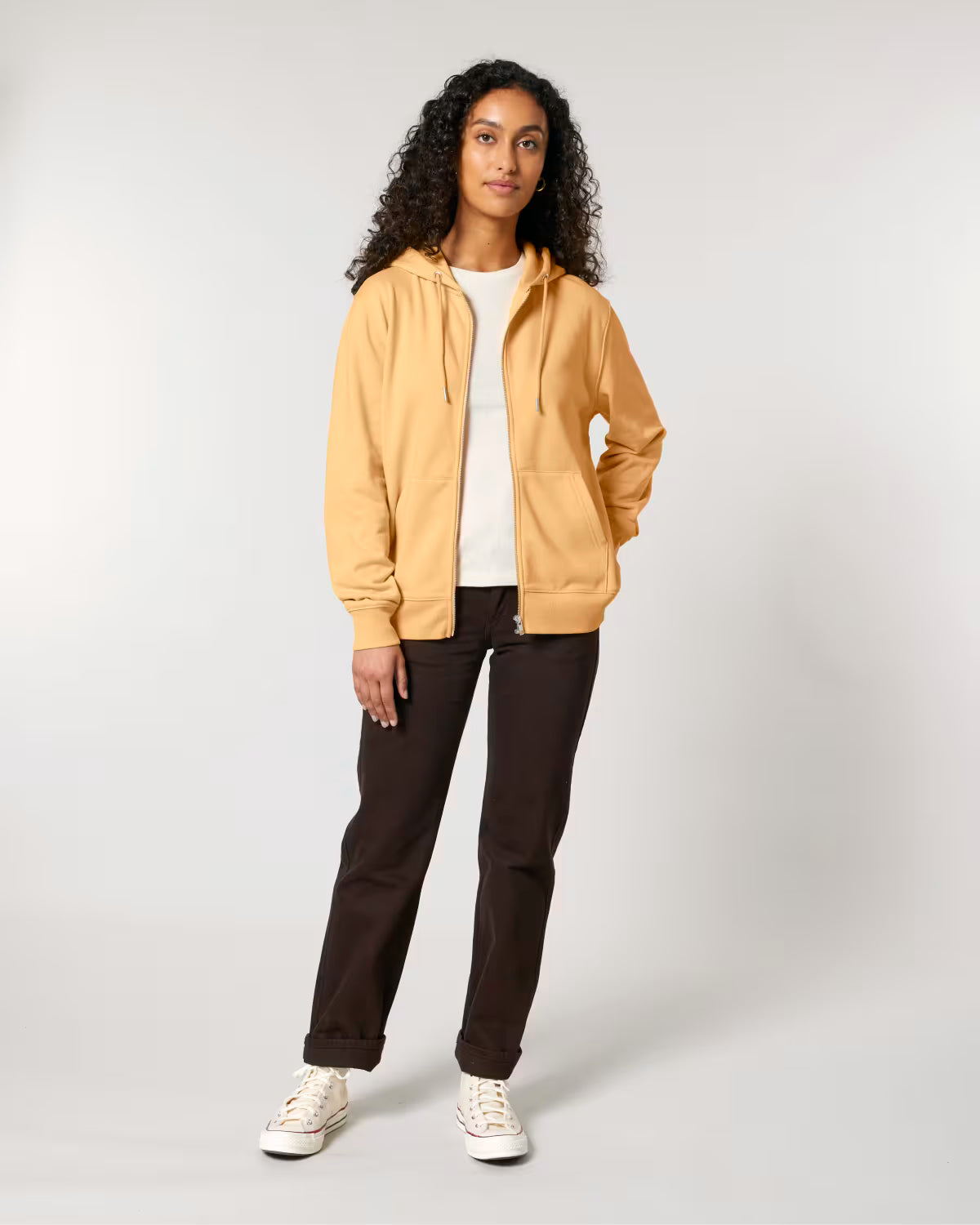 Woman wearing a cotton beige jacket and brown pants on a white background