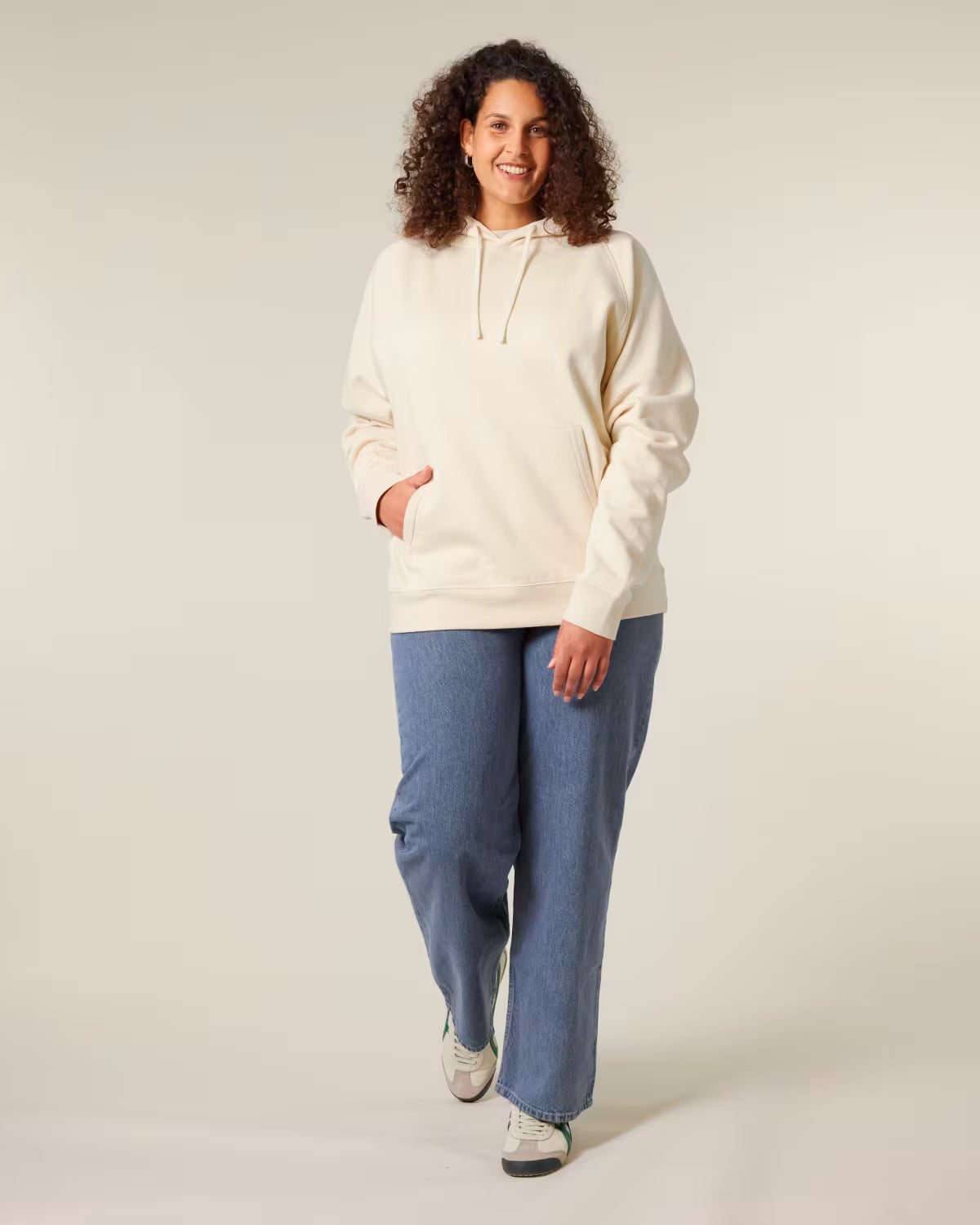 Front view of a female model wearing a beige orange cotton hoodie in studio