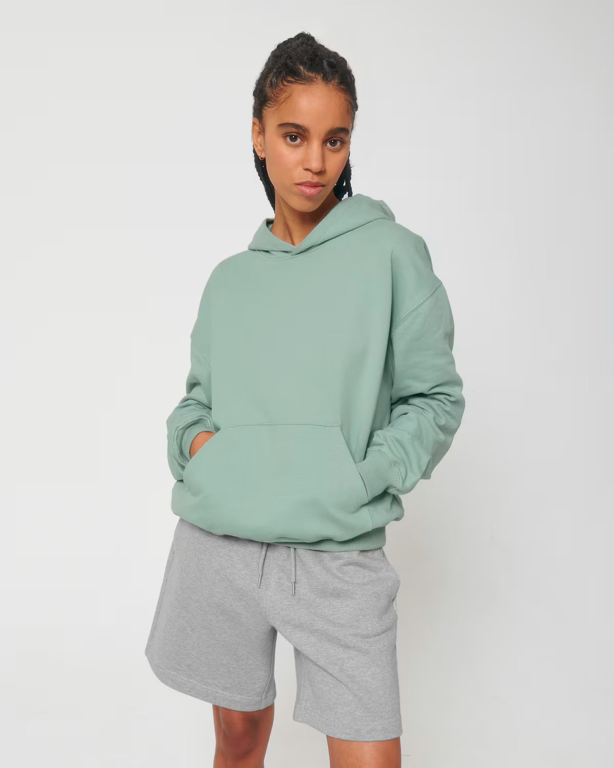 Front view of a female model wearing a mint green cotton hoodie in studio