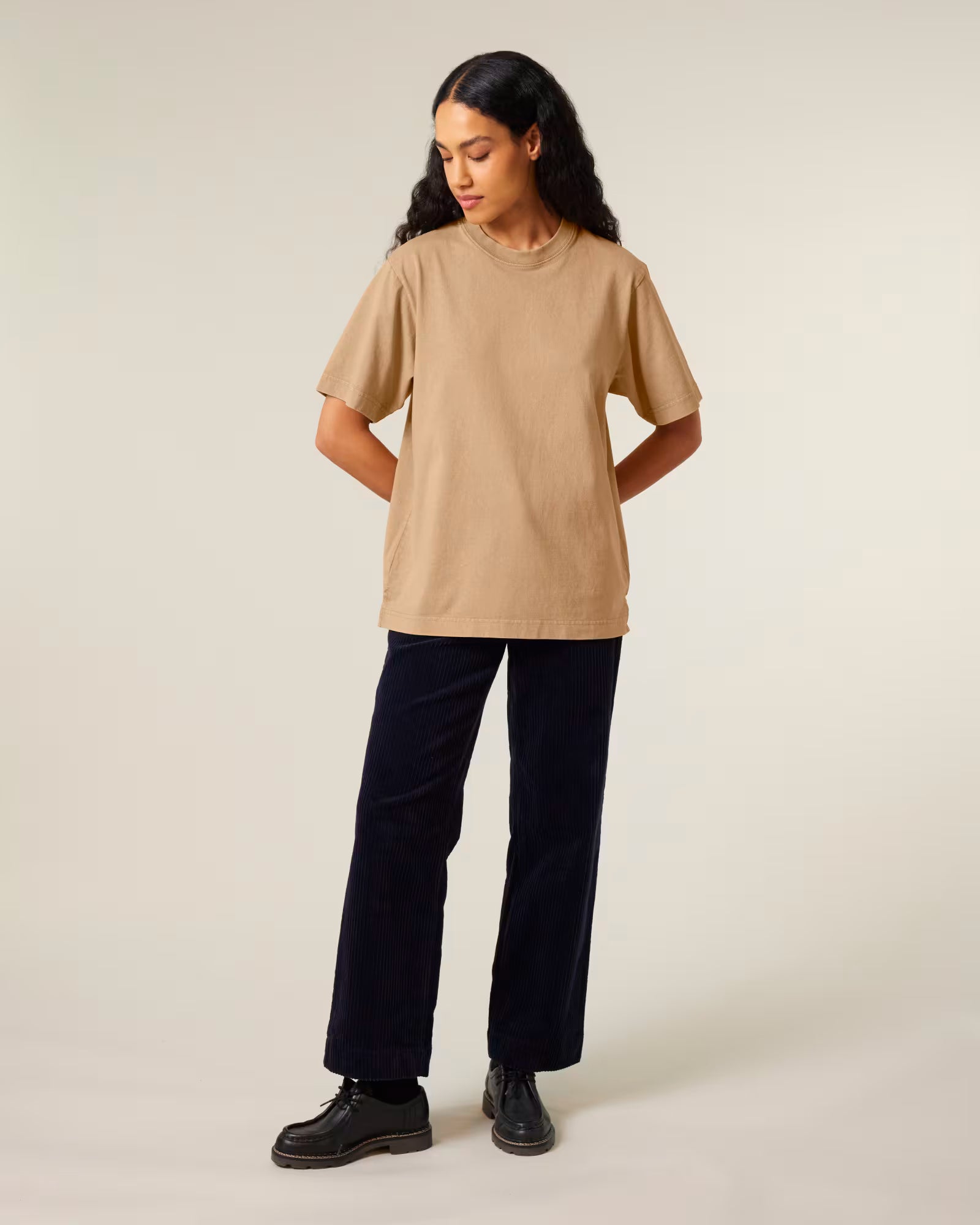 Full body front view of a female model wearing a sand beige cotton t-shirt in studio