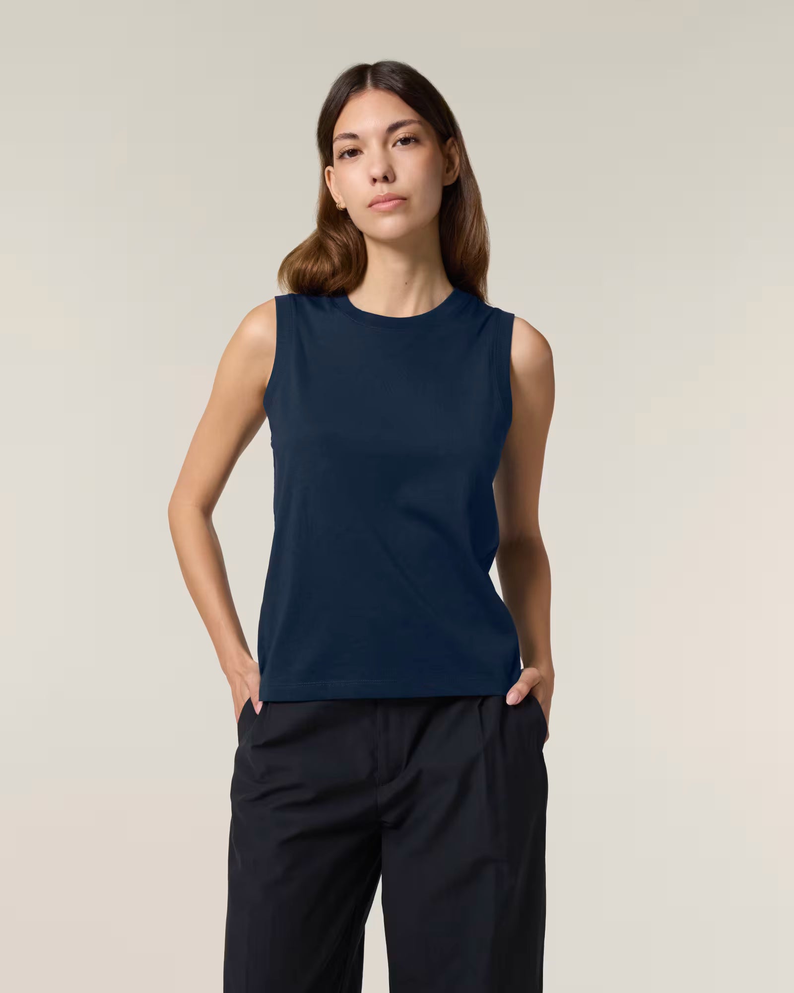 Front view of a female model wearing a navy cotton sleeveless top in studio